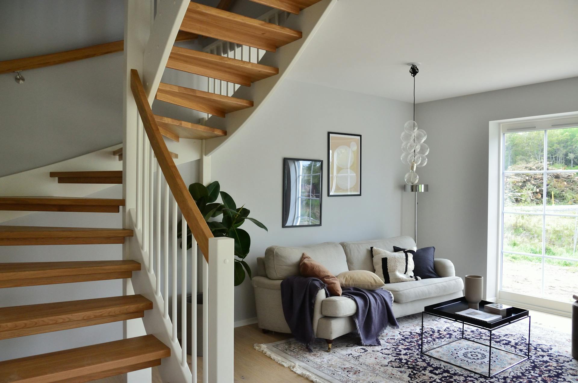A house interior featuring a white sofa beside a staircase | Source: Pexels