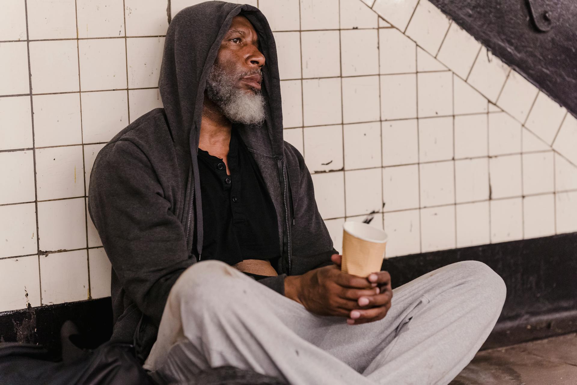 A homeless man holding a paper cup | Source: Pexels