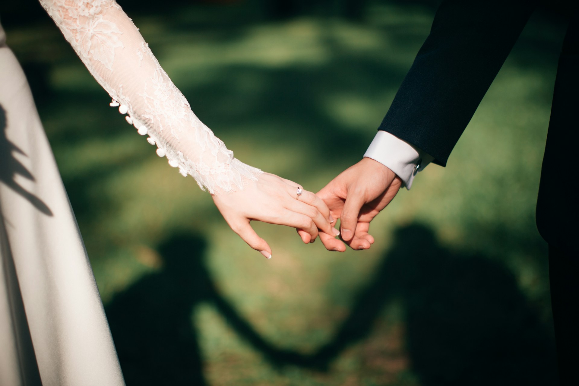 A couple holding hands on their wedding day | Source: Unsplash