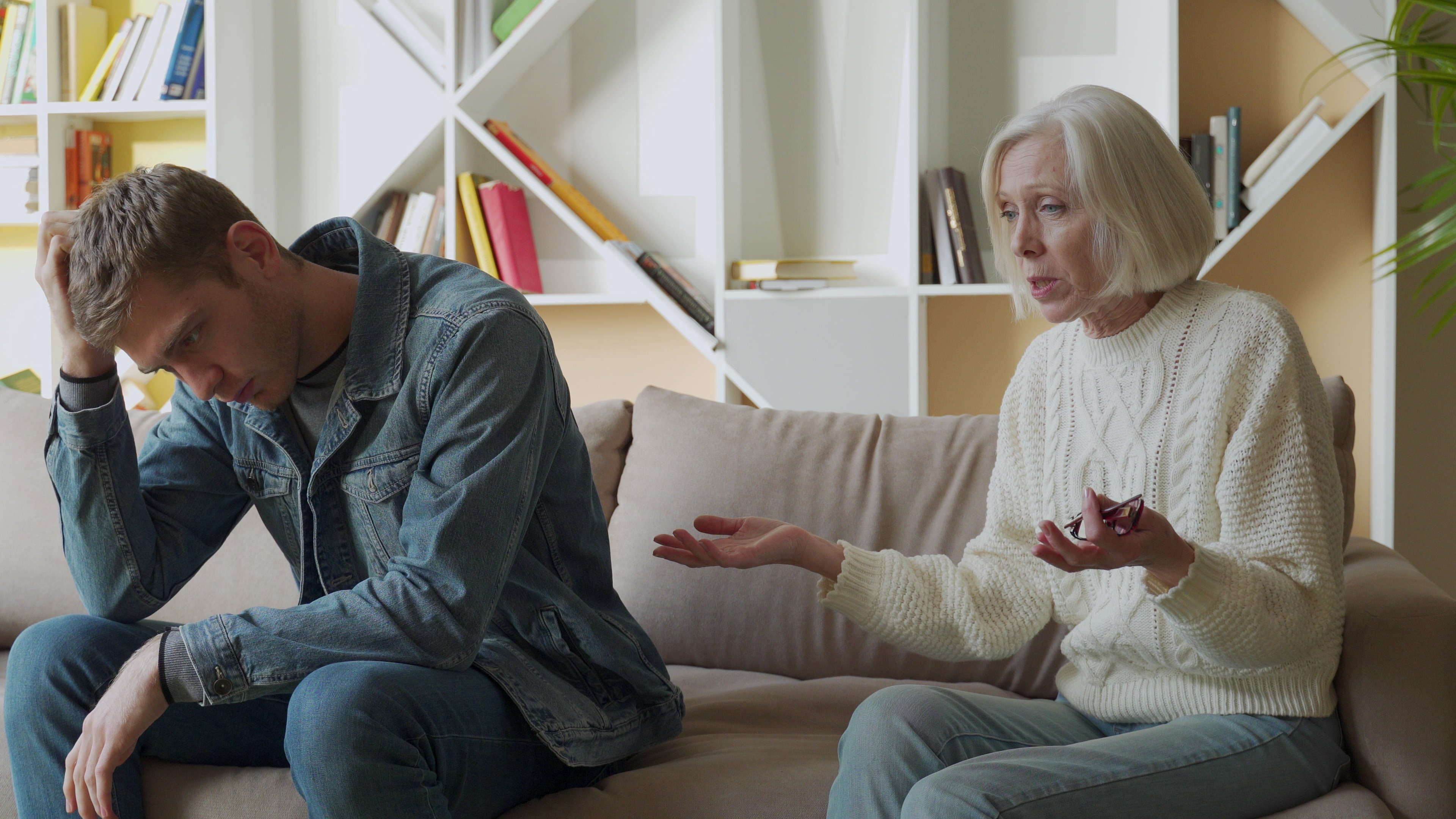 A tired man listening to his livid mother | Source: Shutterstock