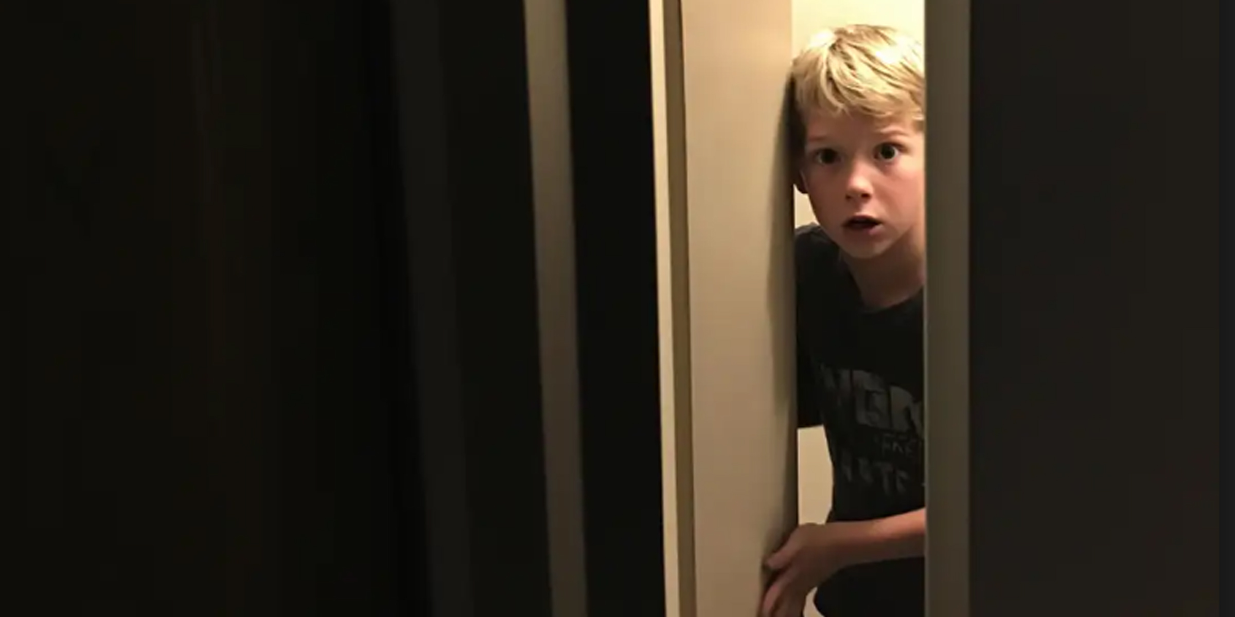 A frightened boy slowly opening the door | Source: Midjourney