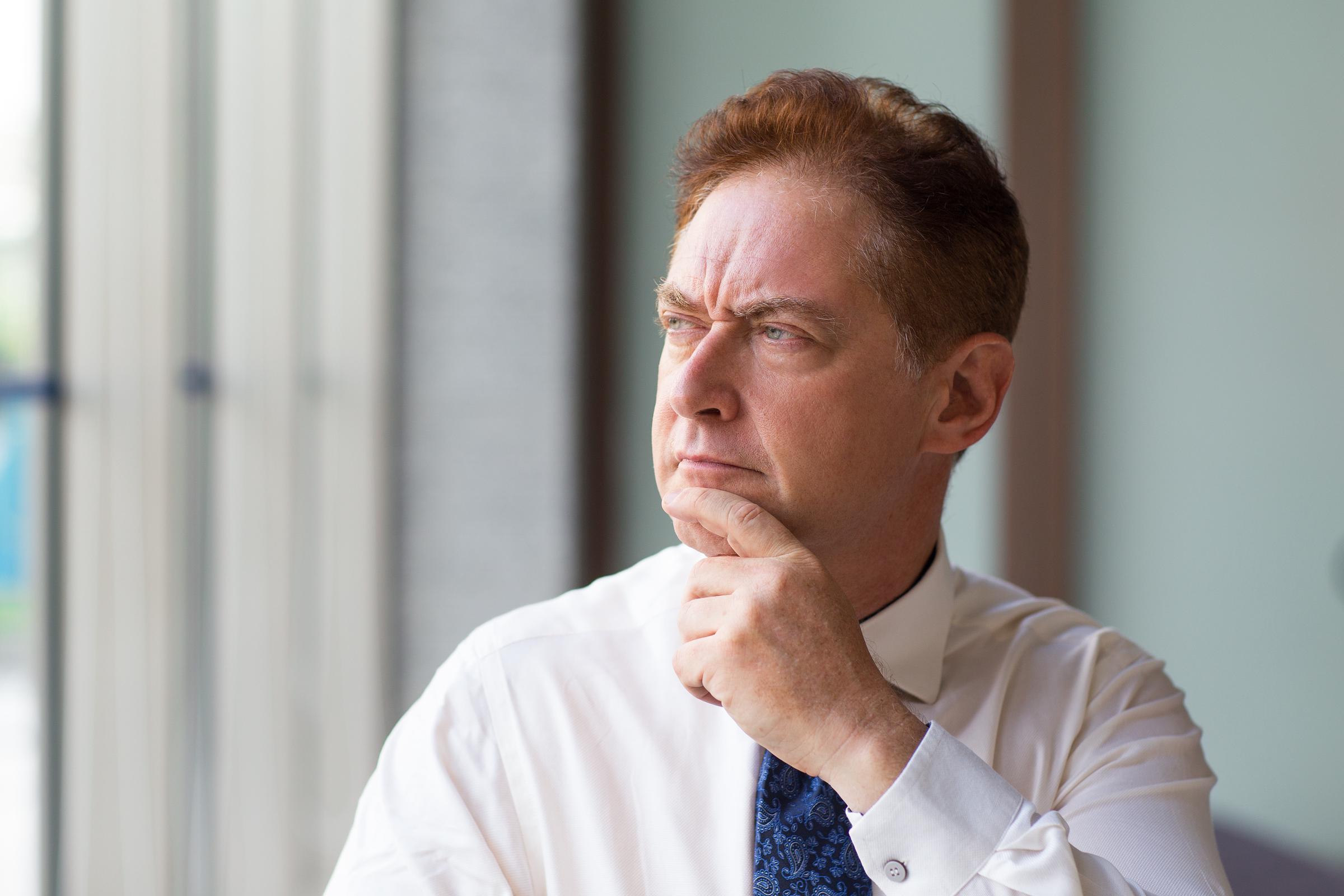 A confused man holding his chin | Source: Freepik