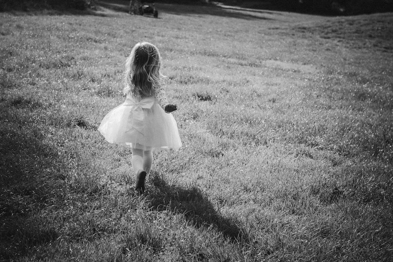 Grayscale shot of a little girl running away | Source: Pexels