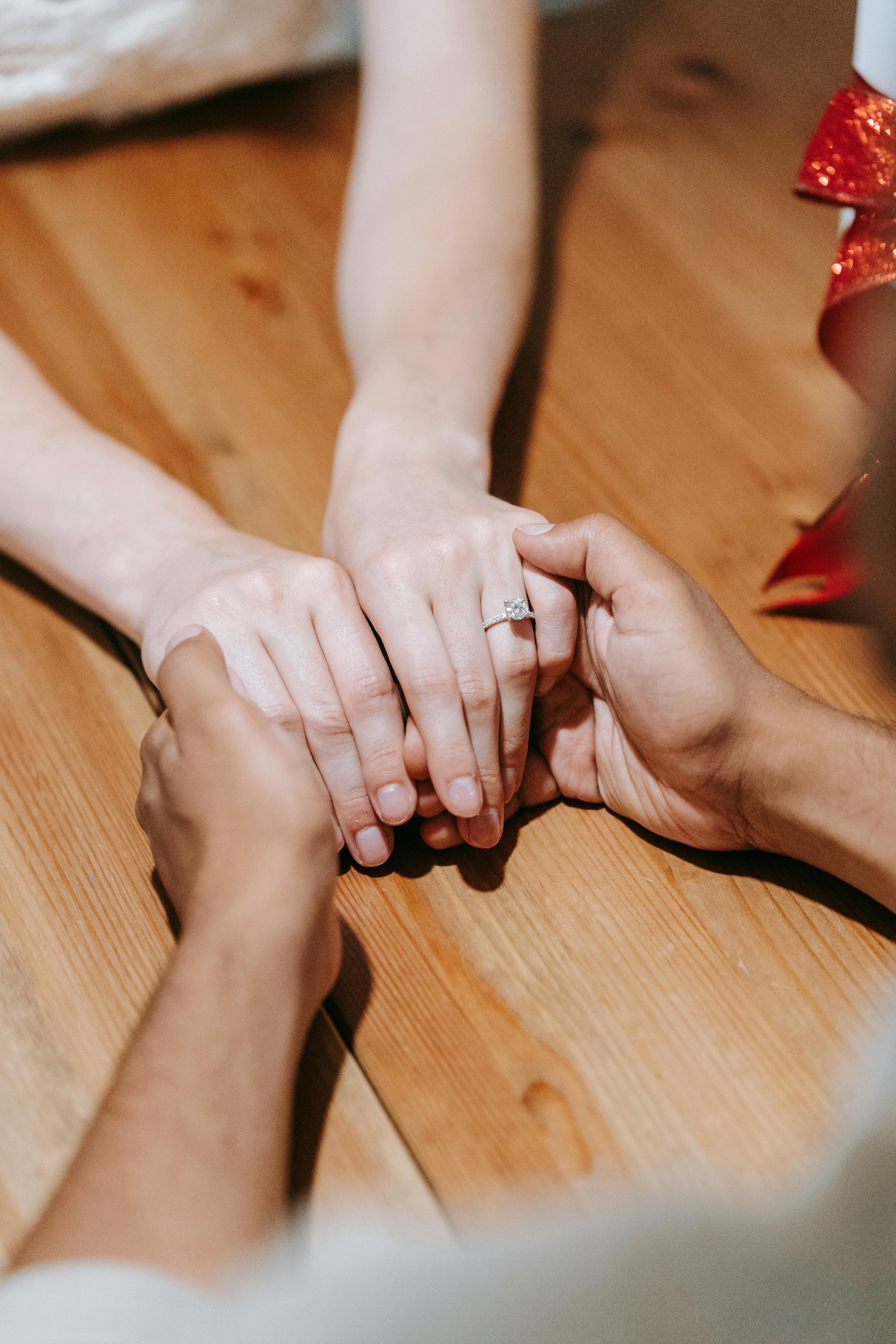 A couple holding hands across a table | Source: Pexels