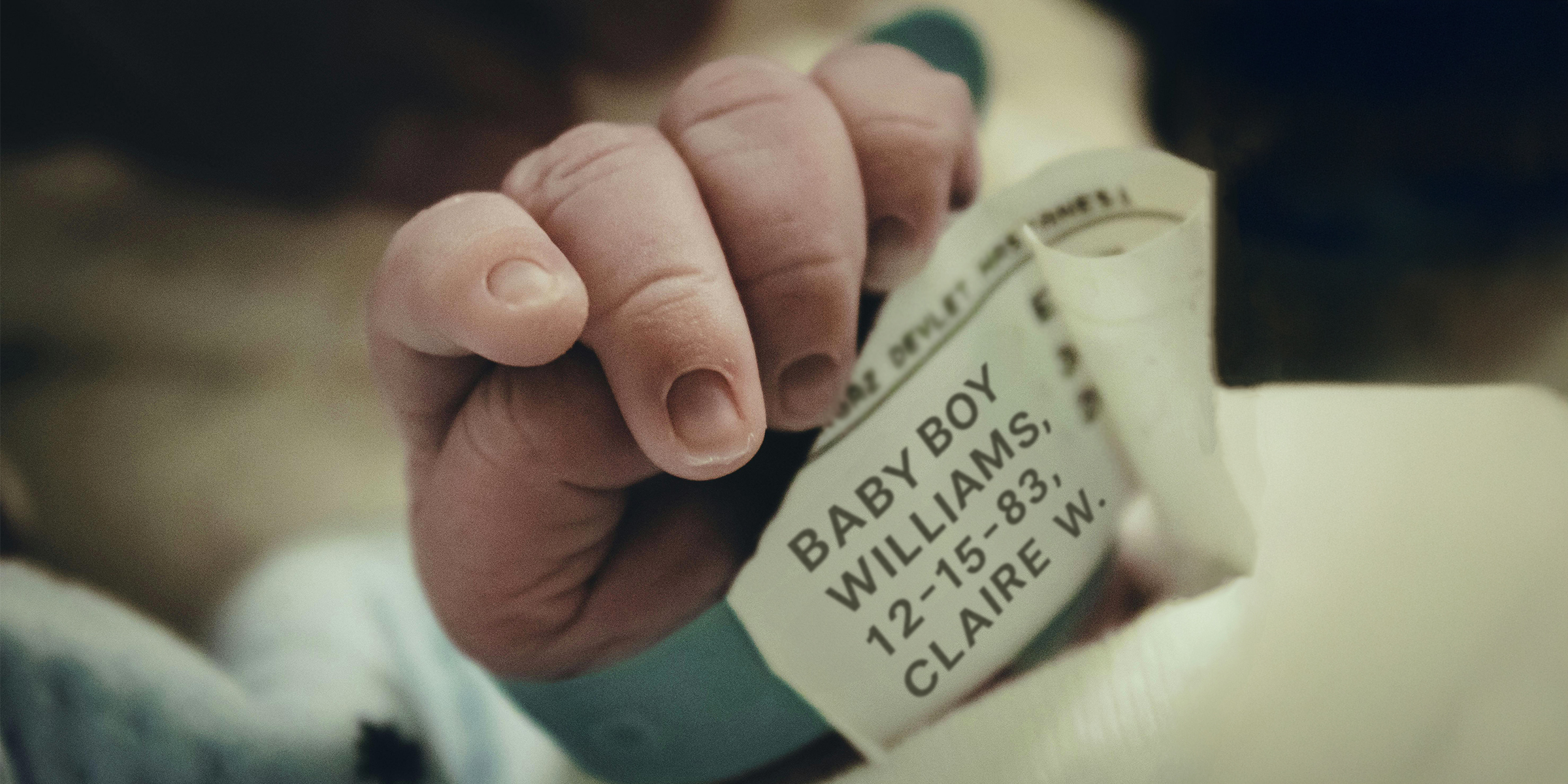 Newborn's tiny hand with a birth bracelet on it | Source: Pexels