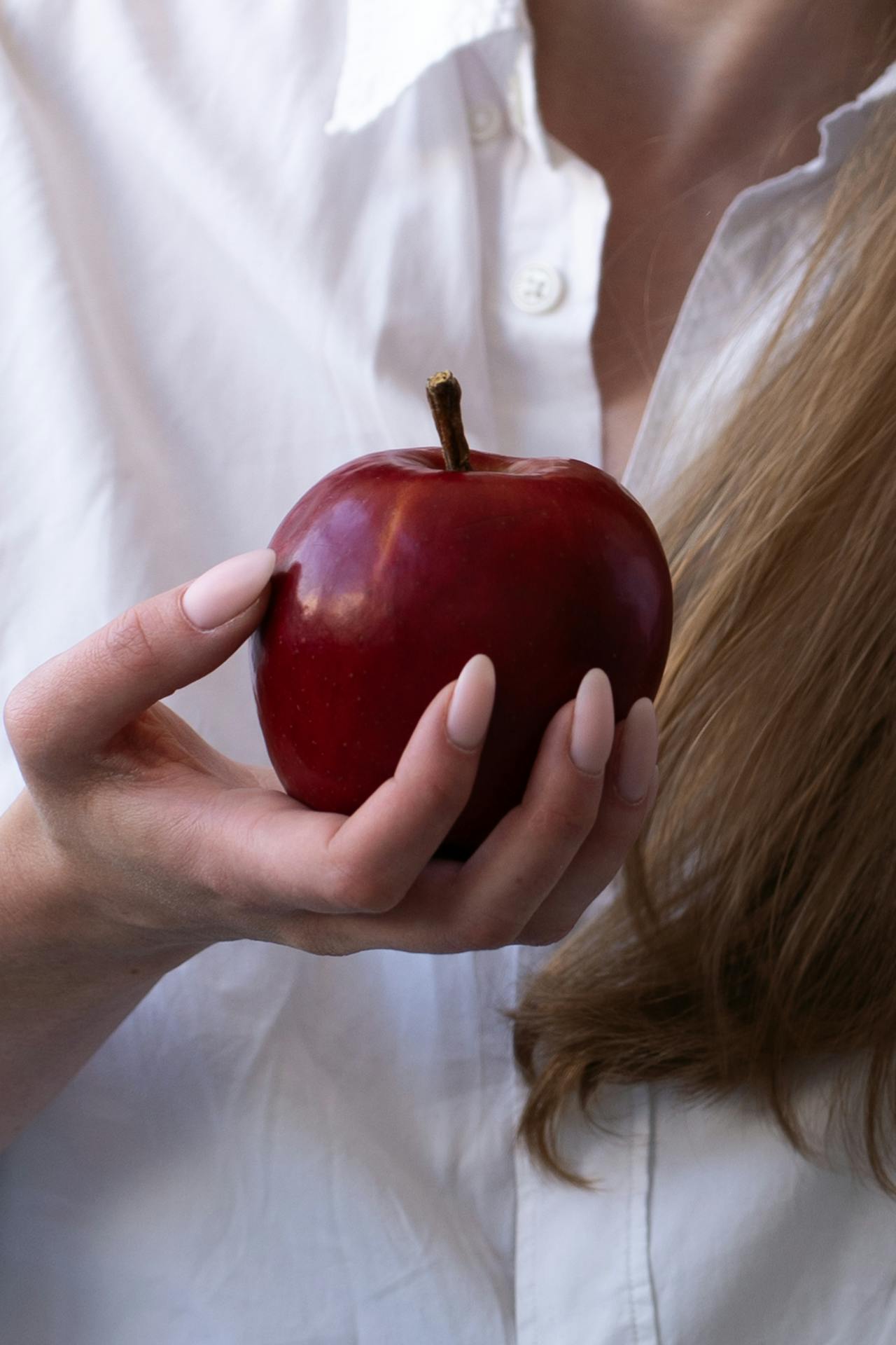 A woman holding an apple | Source: Pexels