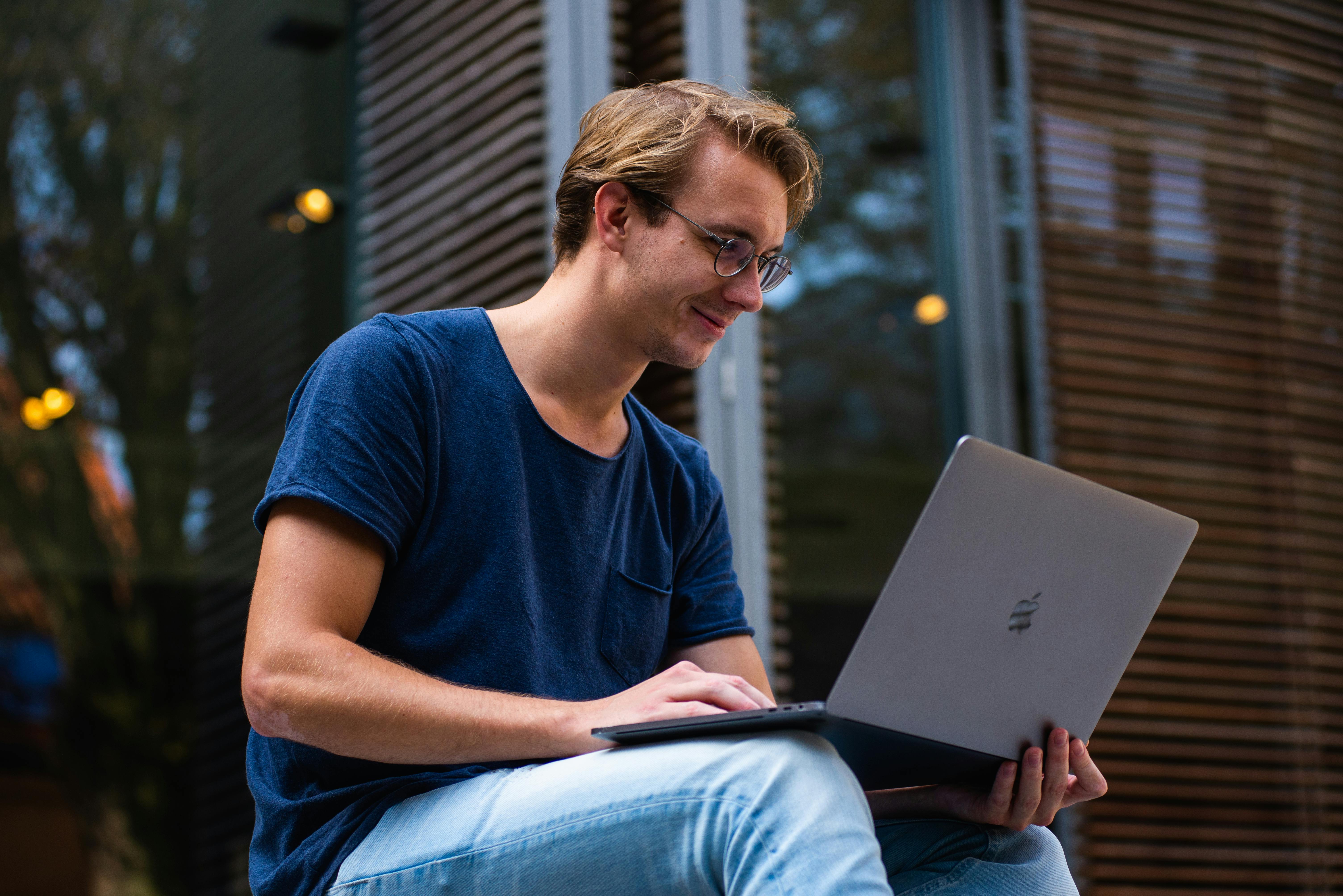 A smiling man with a laptop | Source: Pexels