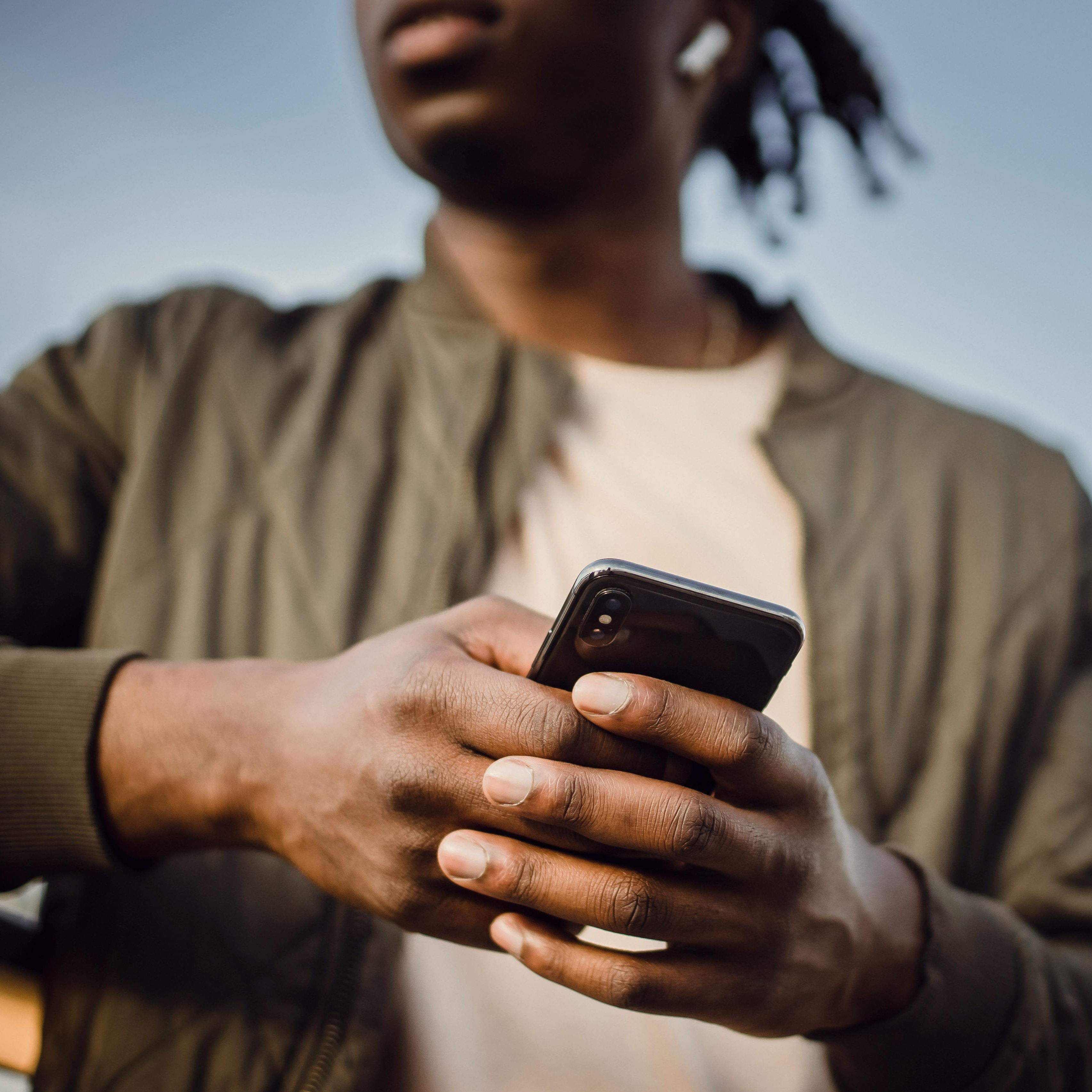 A man making a mobile phone call using earbuds | Source: Pexels