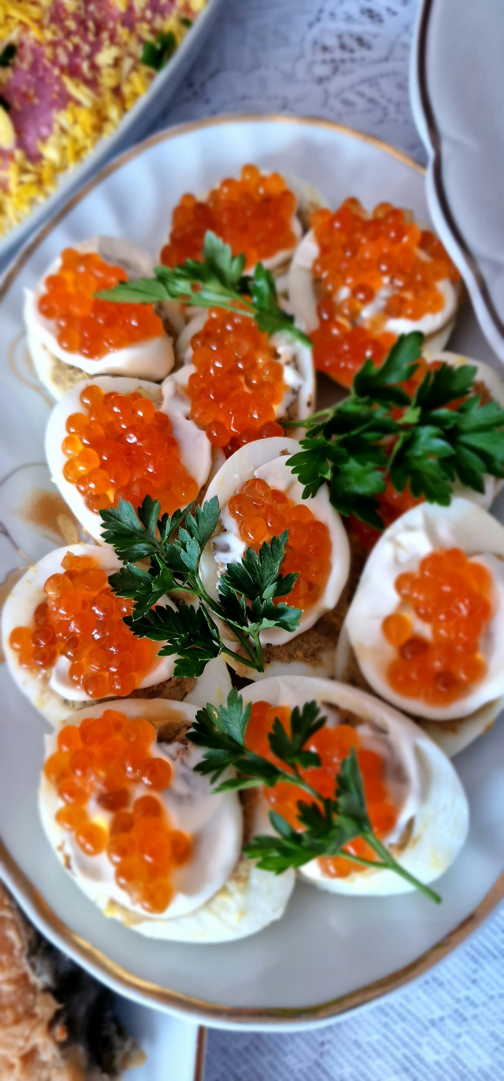 A photo showing gourmet deviled eggs with red caviar and parsley | Source: Pexels