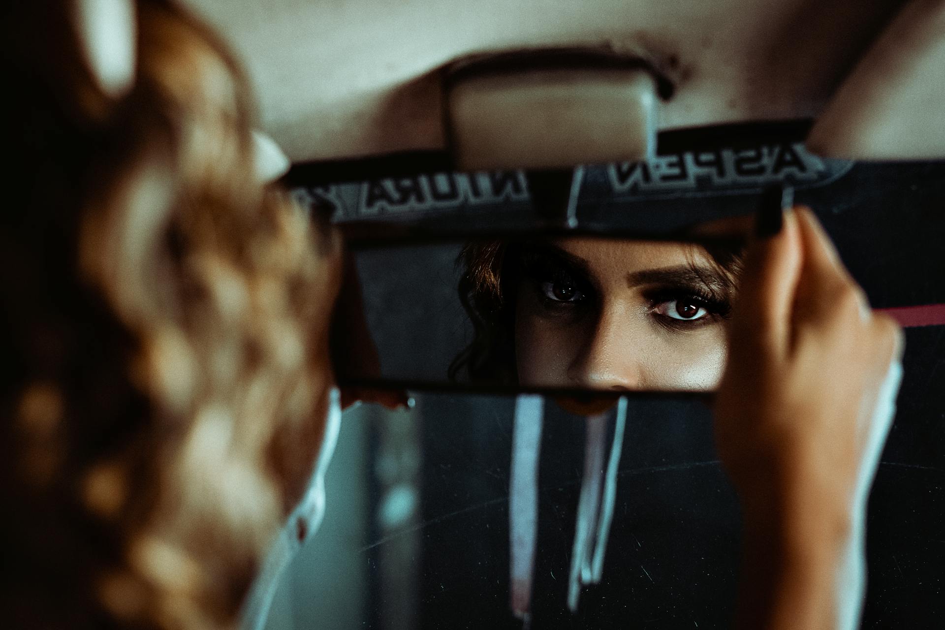 Uma mulher ajustando o espelho retrovisor | Fonte: Pexels