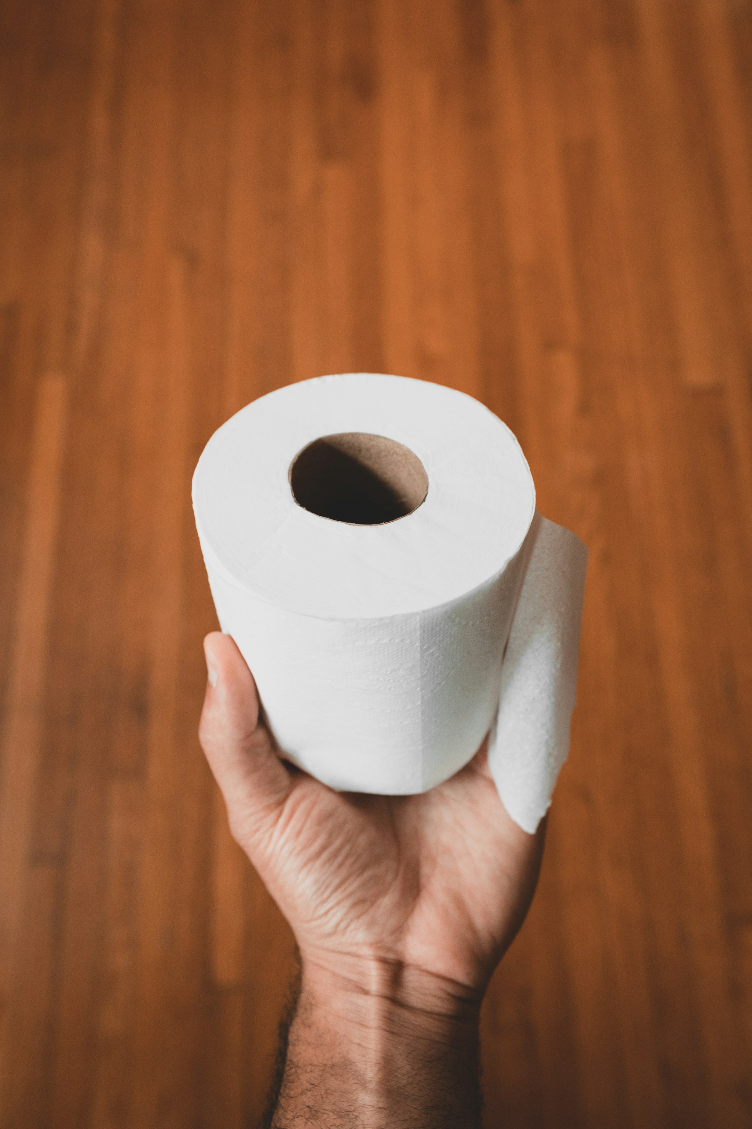 A man holding a toilet paper roll | Source: Unsplash