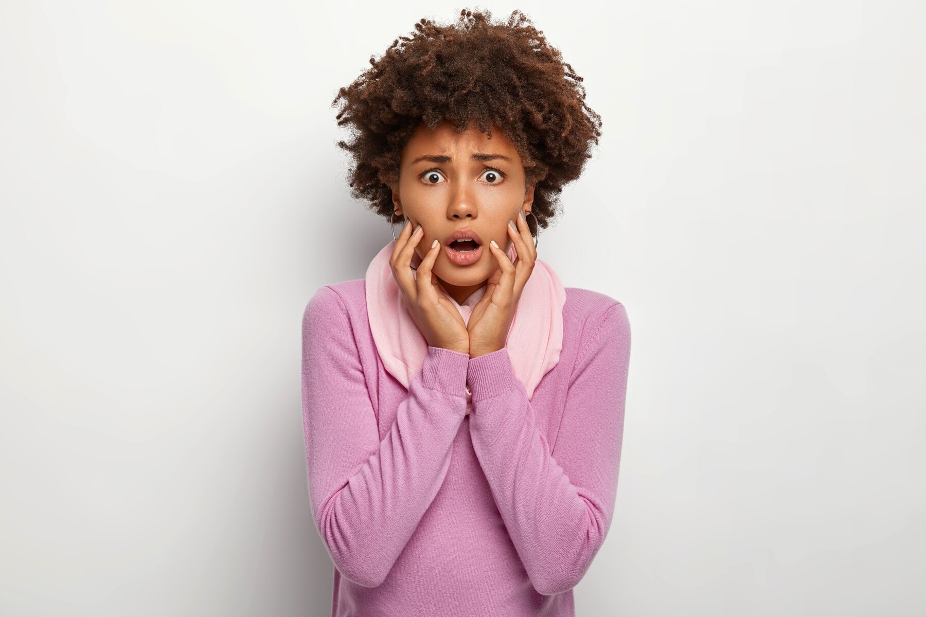 A shocked woman in a pink sweater | Source: Freepik