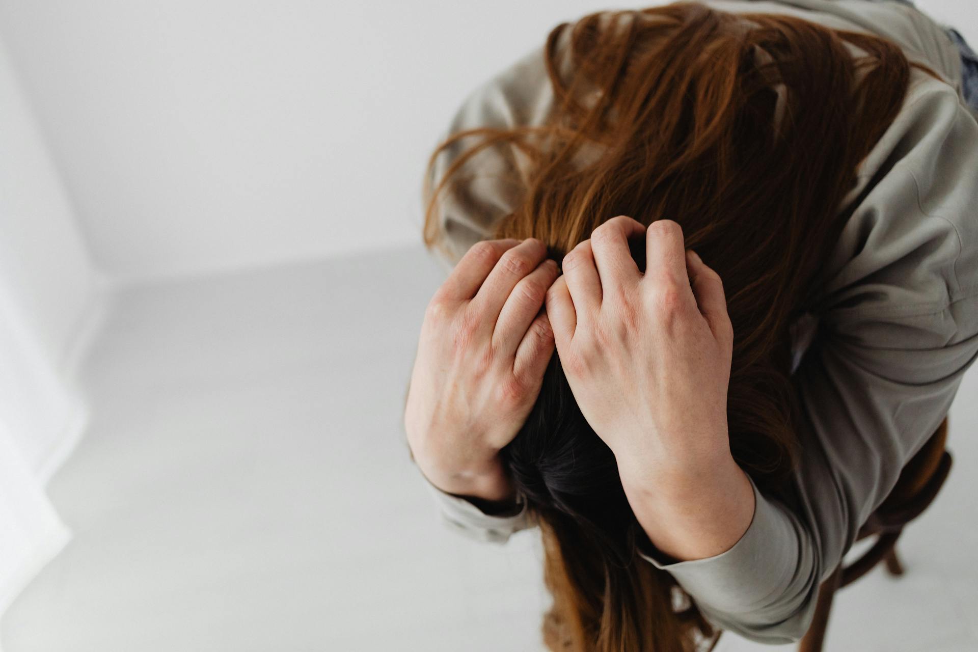 A woman with her head in her hands | Source: Pexels