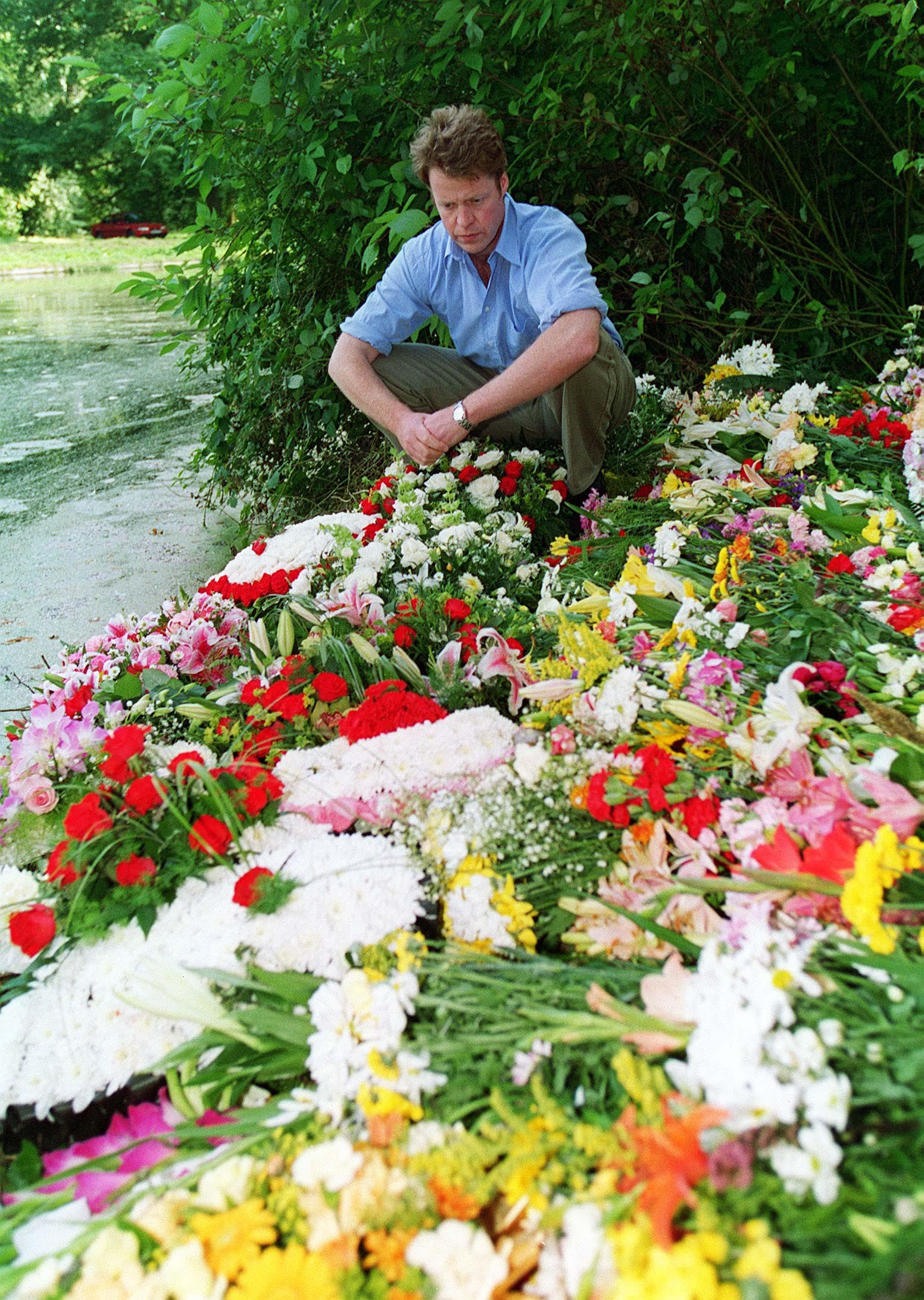 Earl Spencer lays flowers on the island in the grounds of the Spencer family home at Althorp, Northamptonshire, on September 8, 1997, where his sister Diana, Princess of Wales was buried. | Source: Getty Images