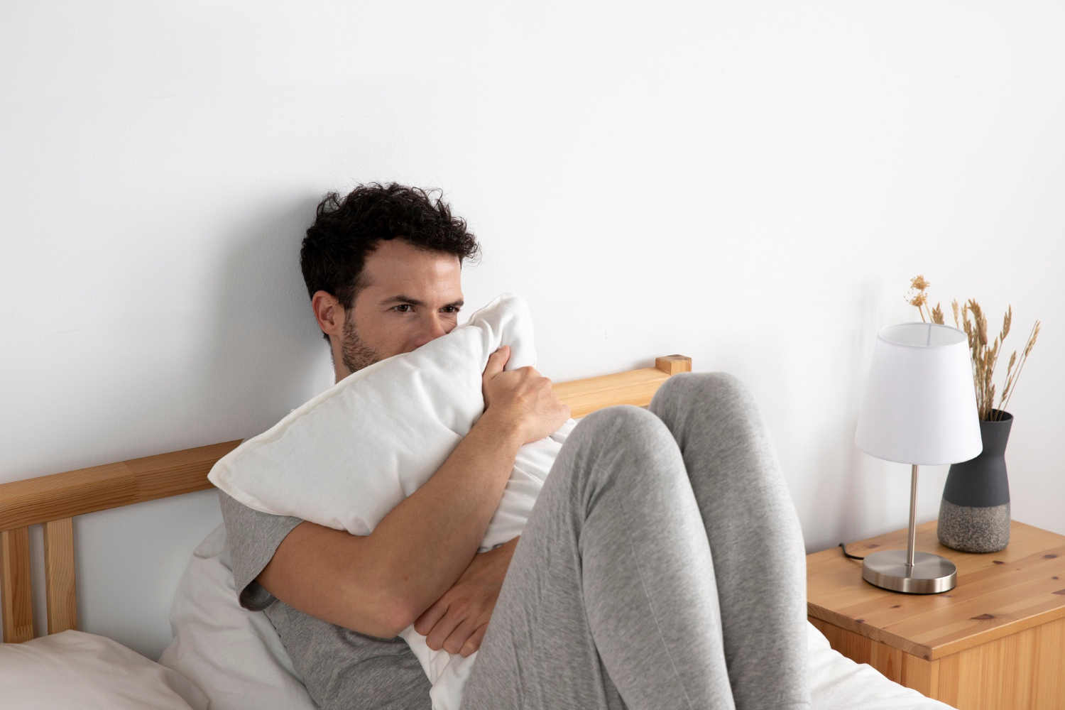 An anxious man sitting on the bed | Source: Freepik