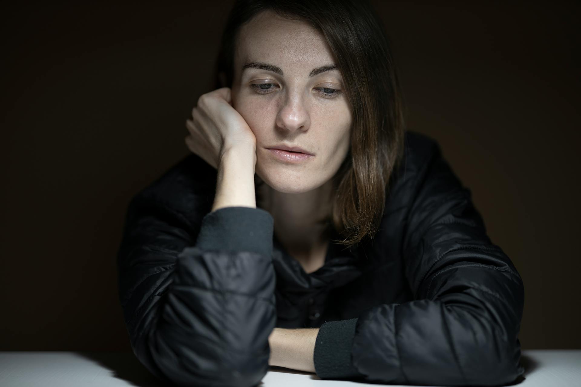 An upset woman sitting at a table | Source: Pexels