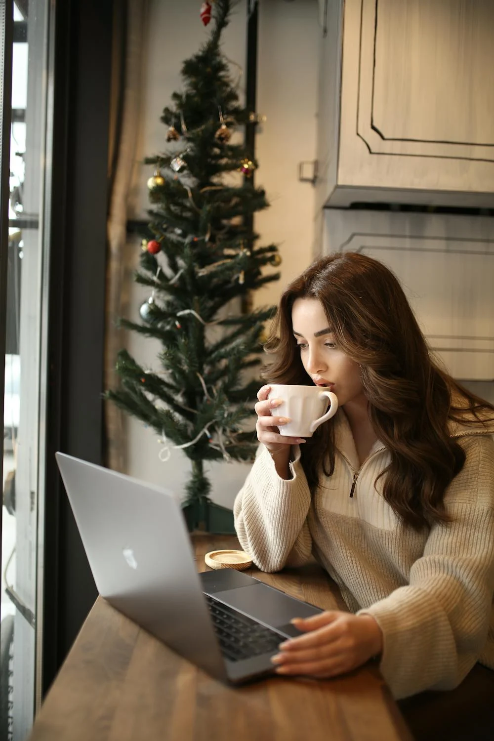 A woman drinking coffee with her laptop | Source: Pexels