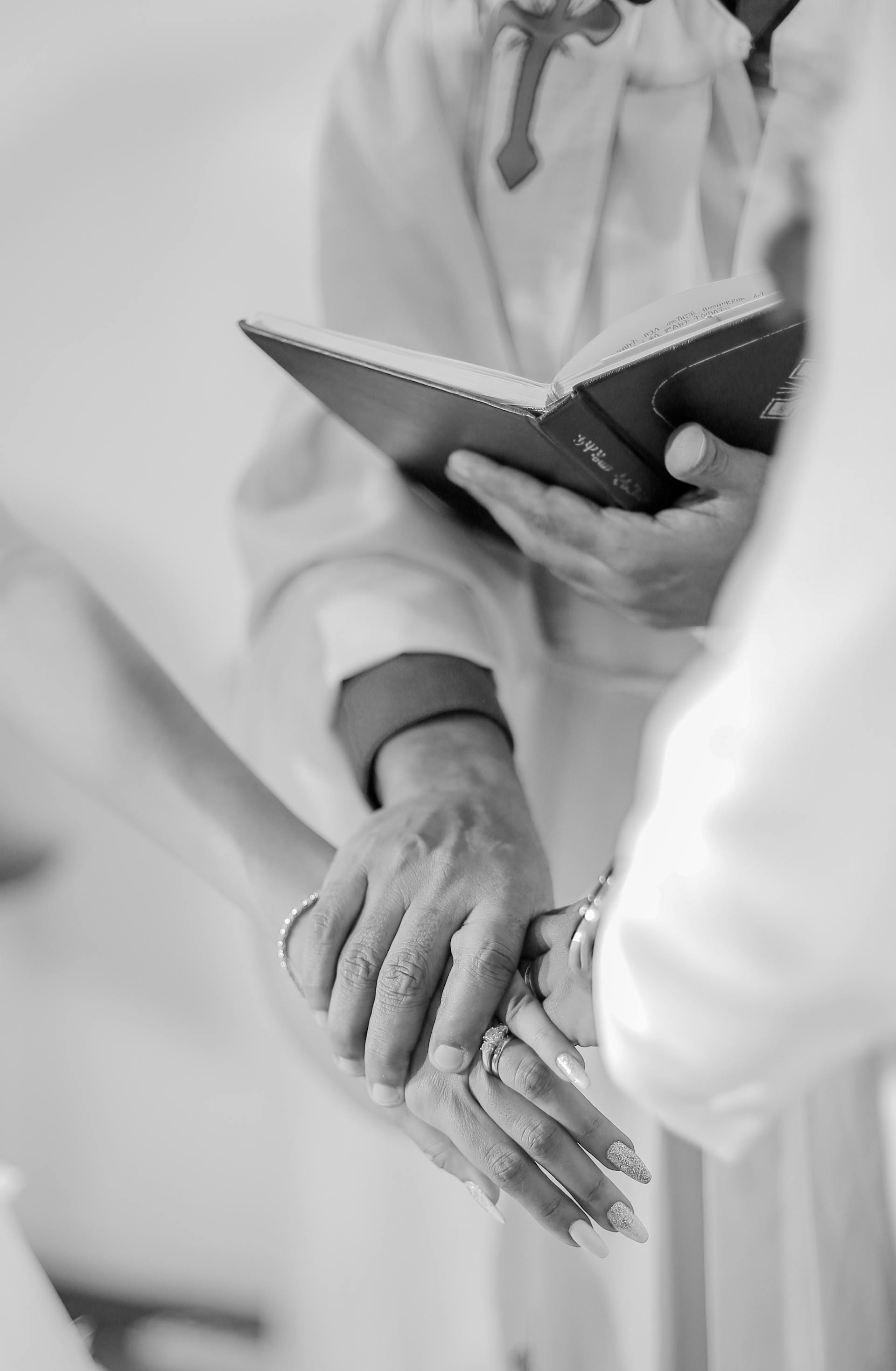 A priest holding a bride and groom | Source: Pexels