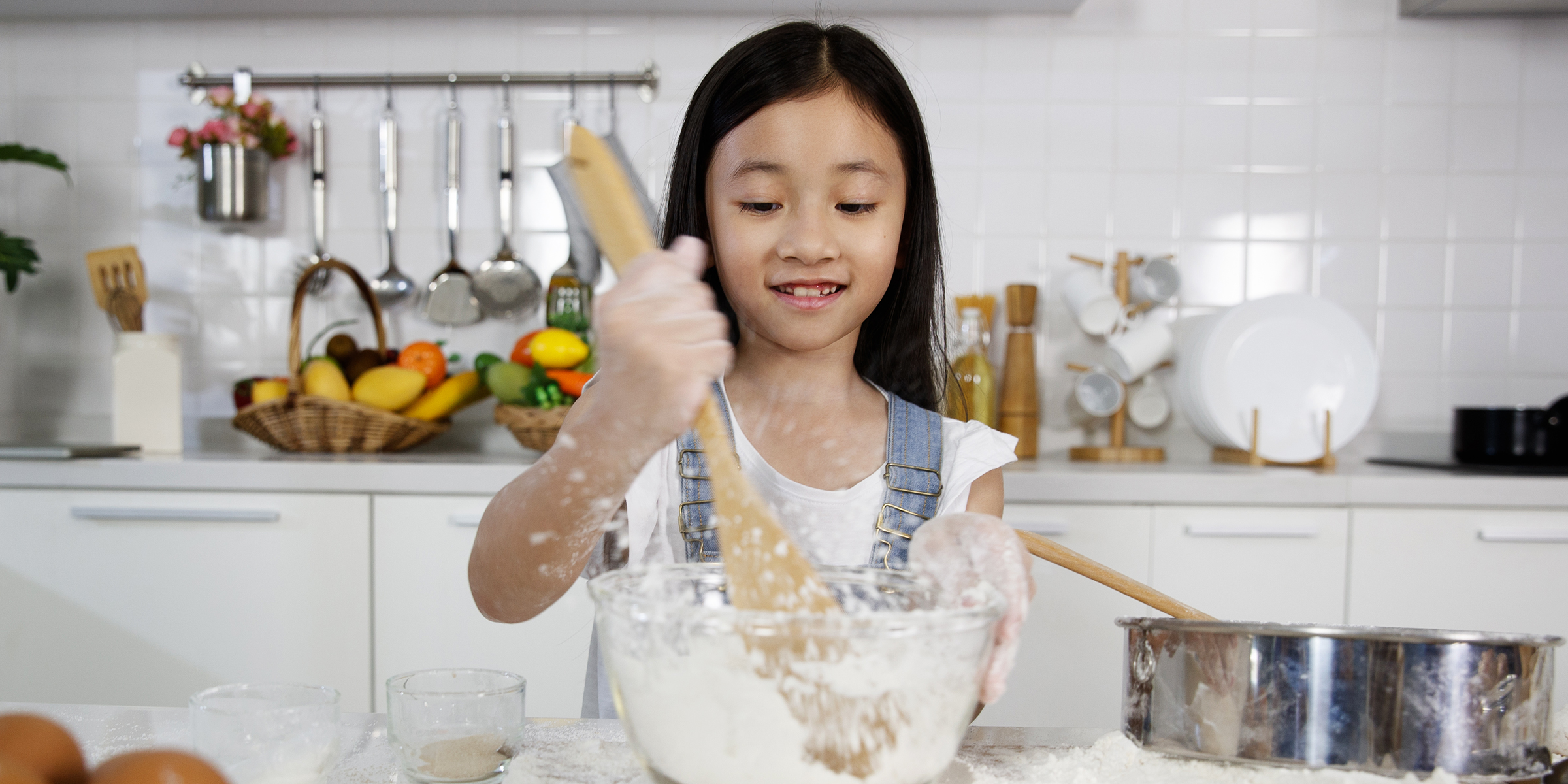 A young girl mixing flour in a bowl | Source: Shutterstock