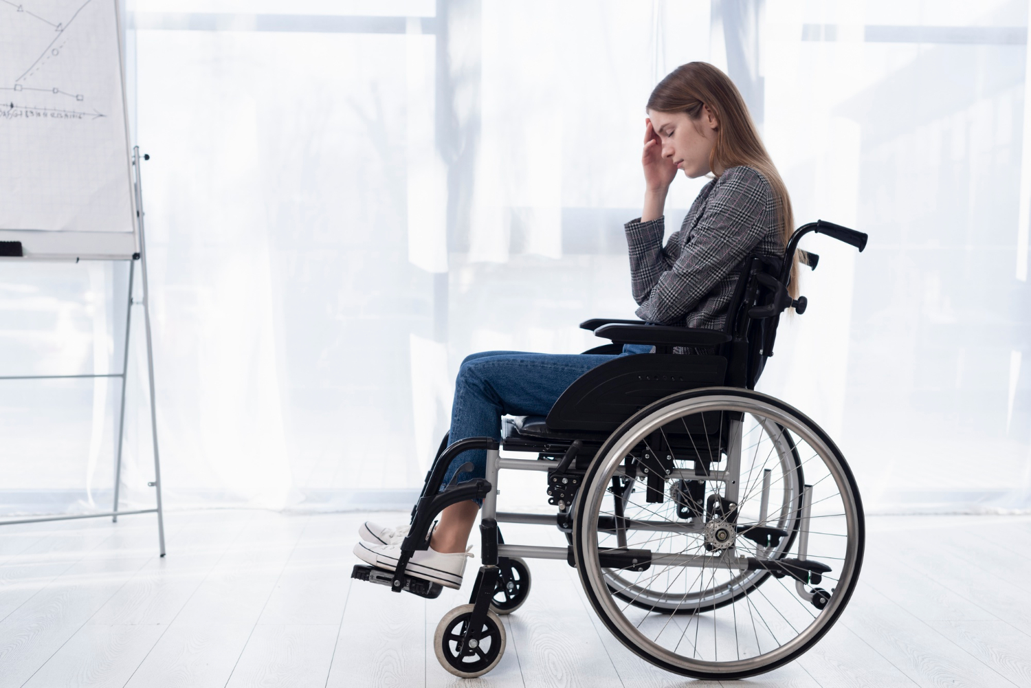 A distressed woman sitting in a wheelchair | Source: Freepik