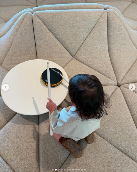 Rocky Thirteen played with drumsticks beside a miniature drum pad in a photo shared by Travis Barker on April 14, 2025, highlighting the toddler's early interest in music. | Source: Instagram/travisbarker