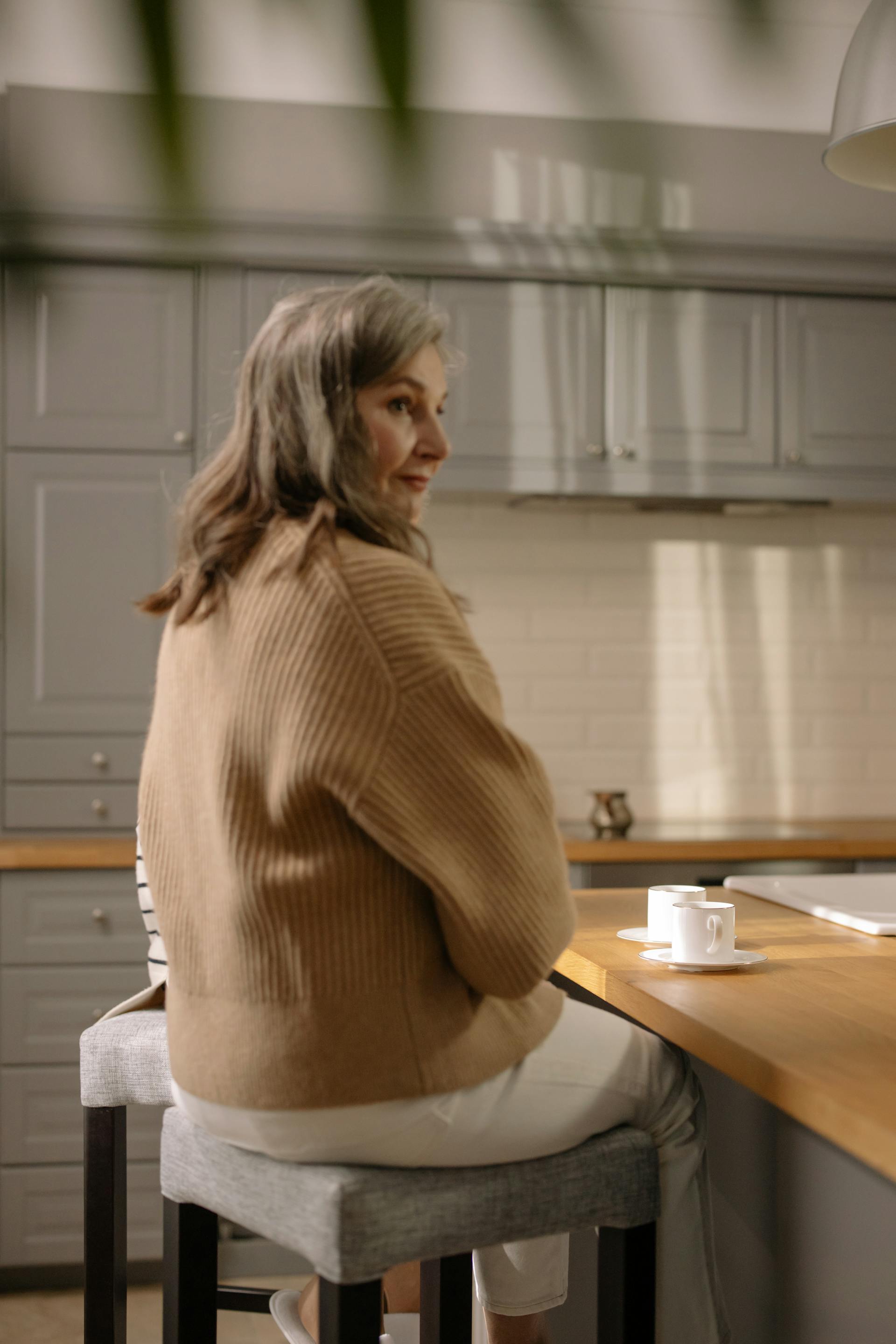 A senior woman sitting on a bar stool | Source: Pexels