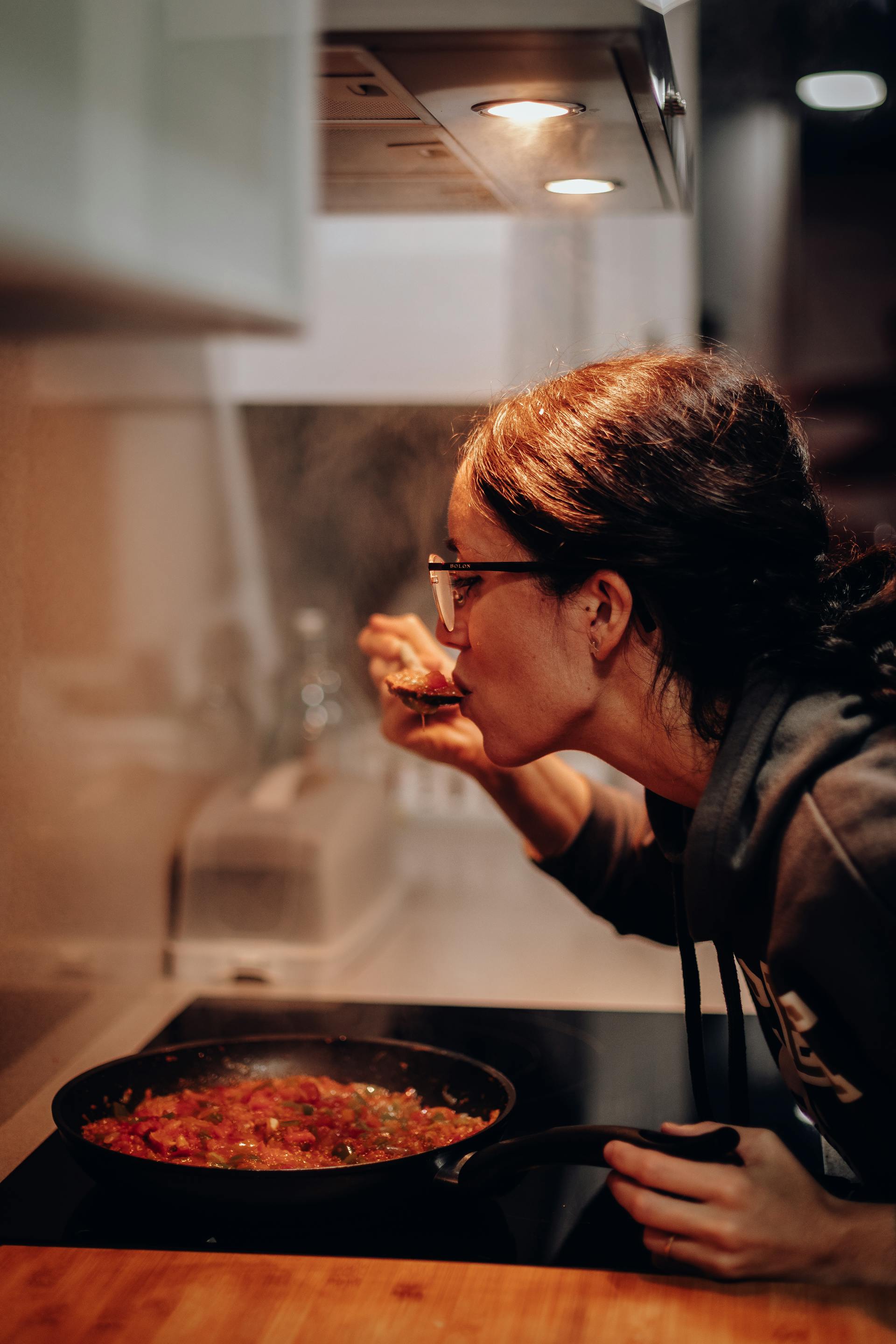 Uma mulher experimentando comida | Fonte: Pexels