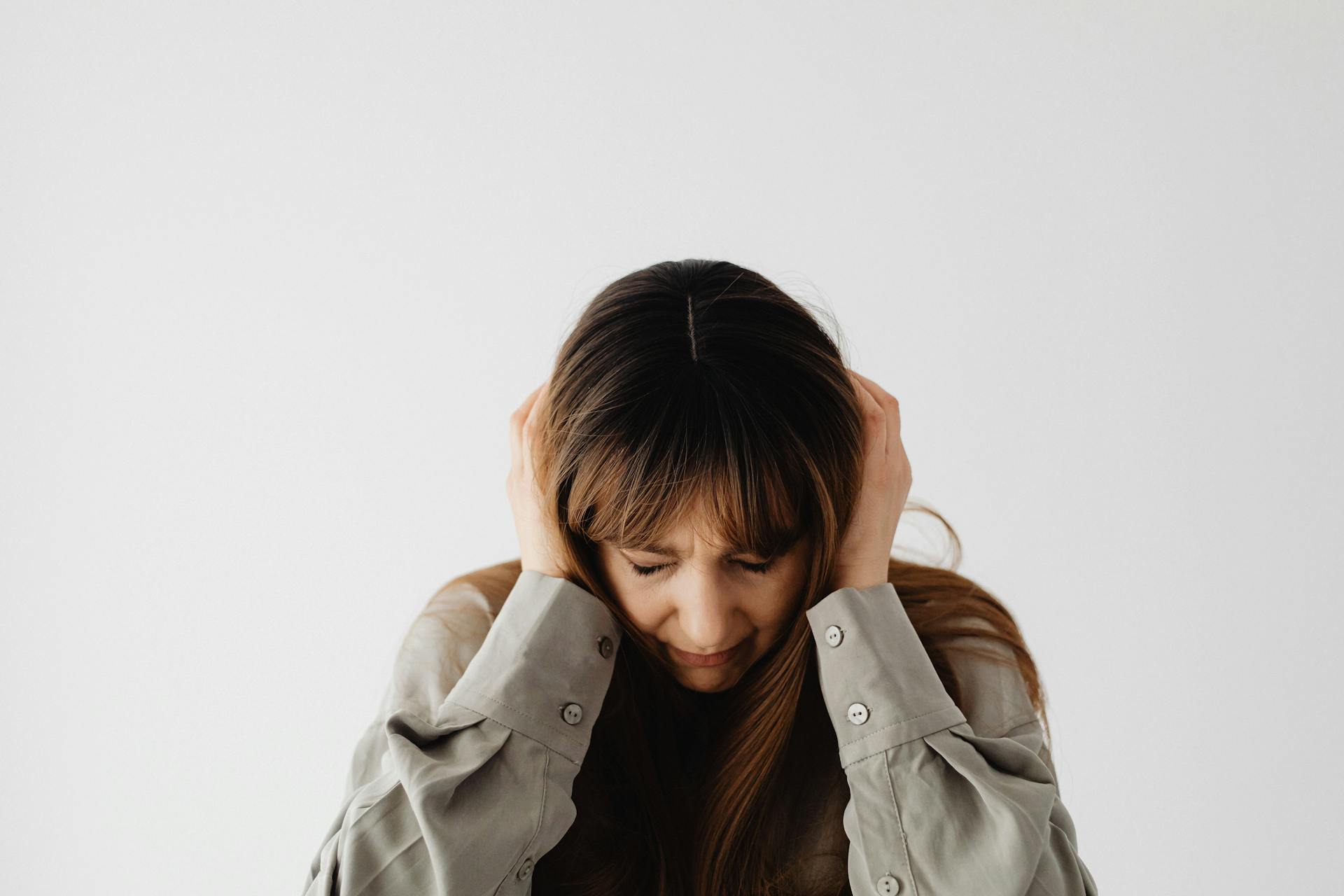 A sad woman sitting with her head in her hands | Source: Pexels