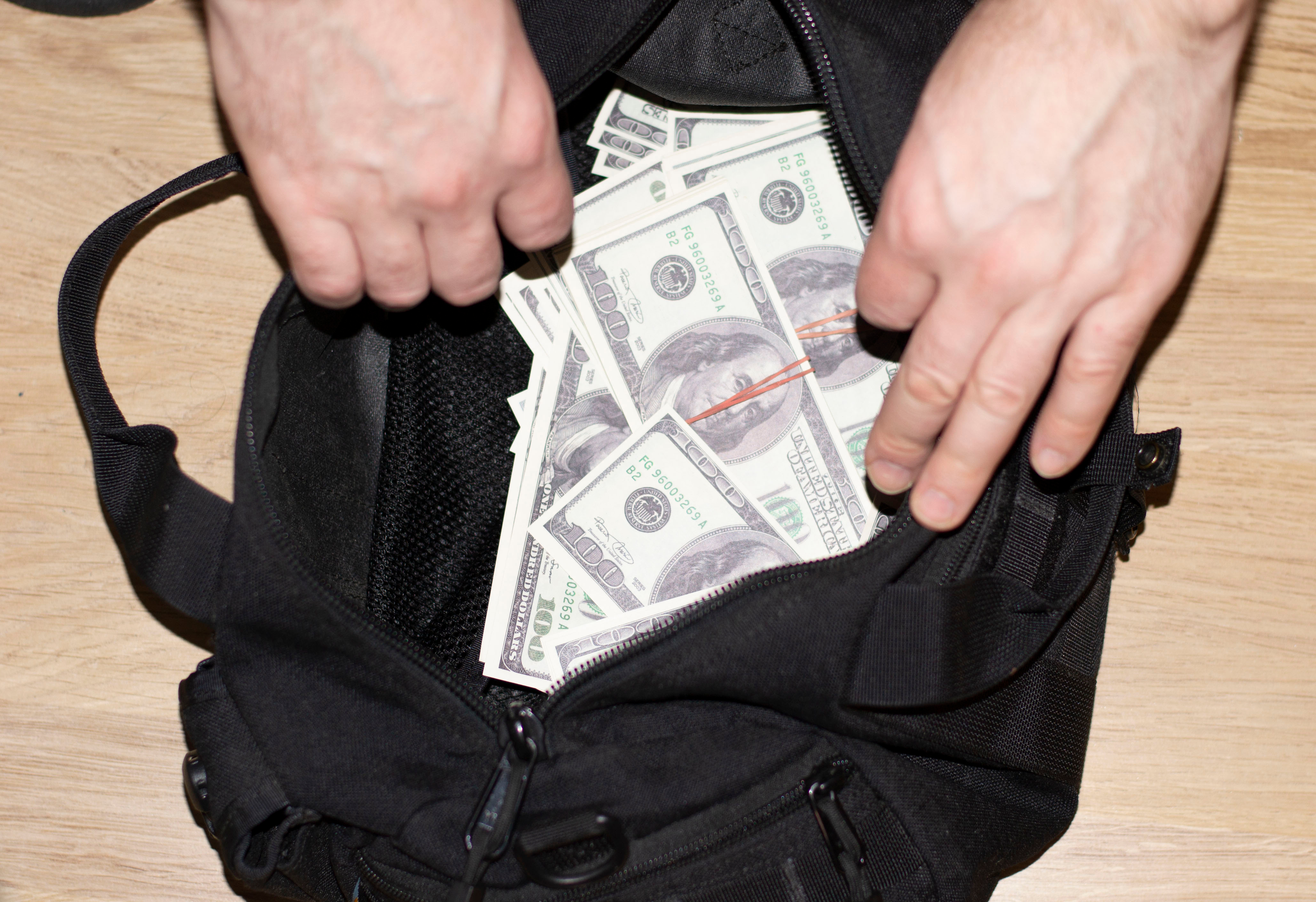 Man's hand open Full Black Duffel Bag | Source: Shutterstock