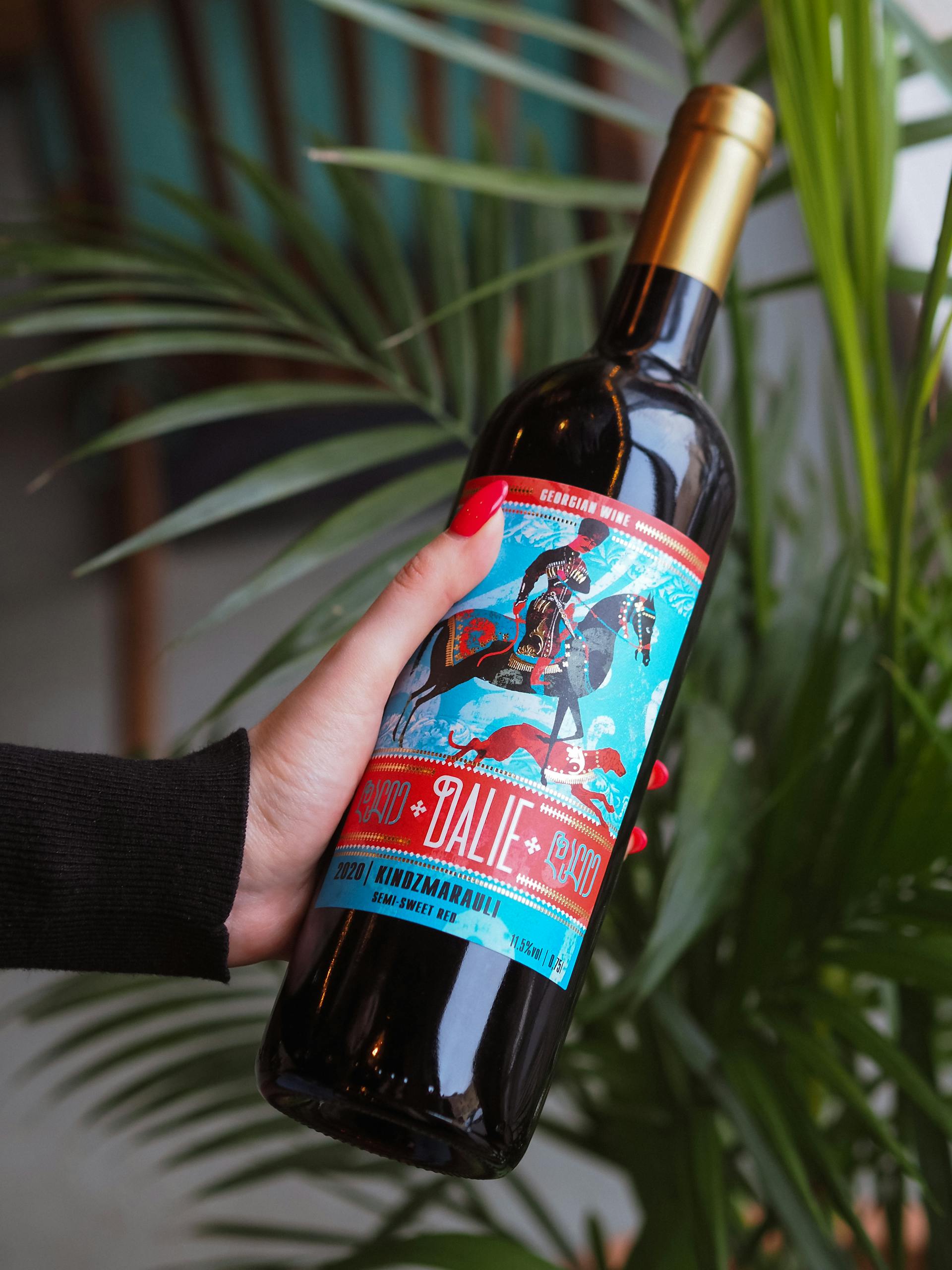 A close-up shot of a woman holding a bottle of wine | Source: Pexels