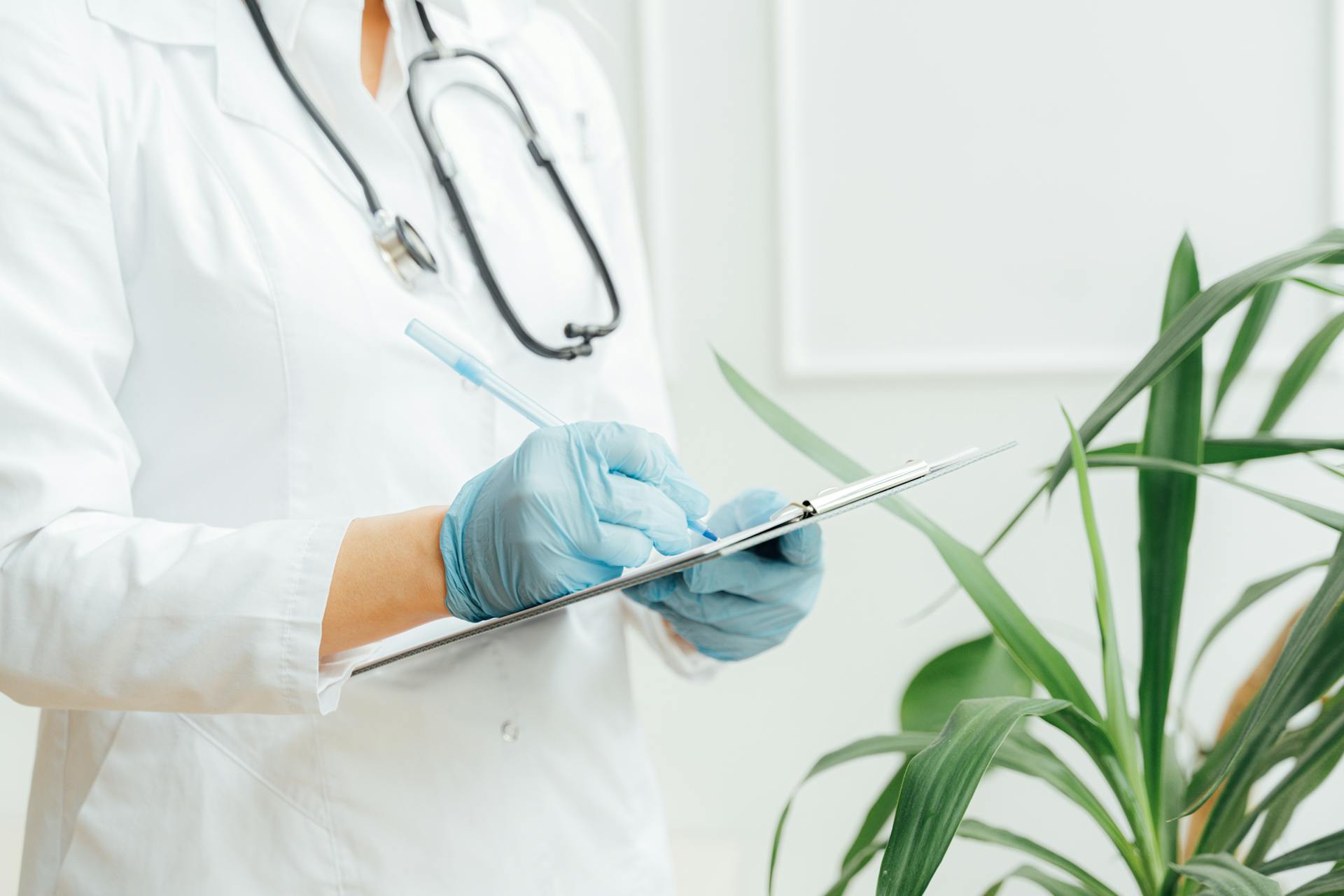 A doctor making notes on a clipboard | Source: Pexels
