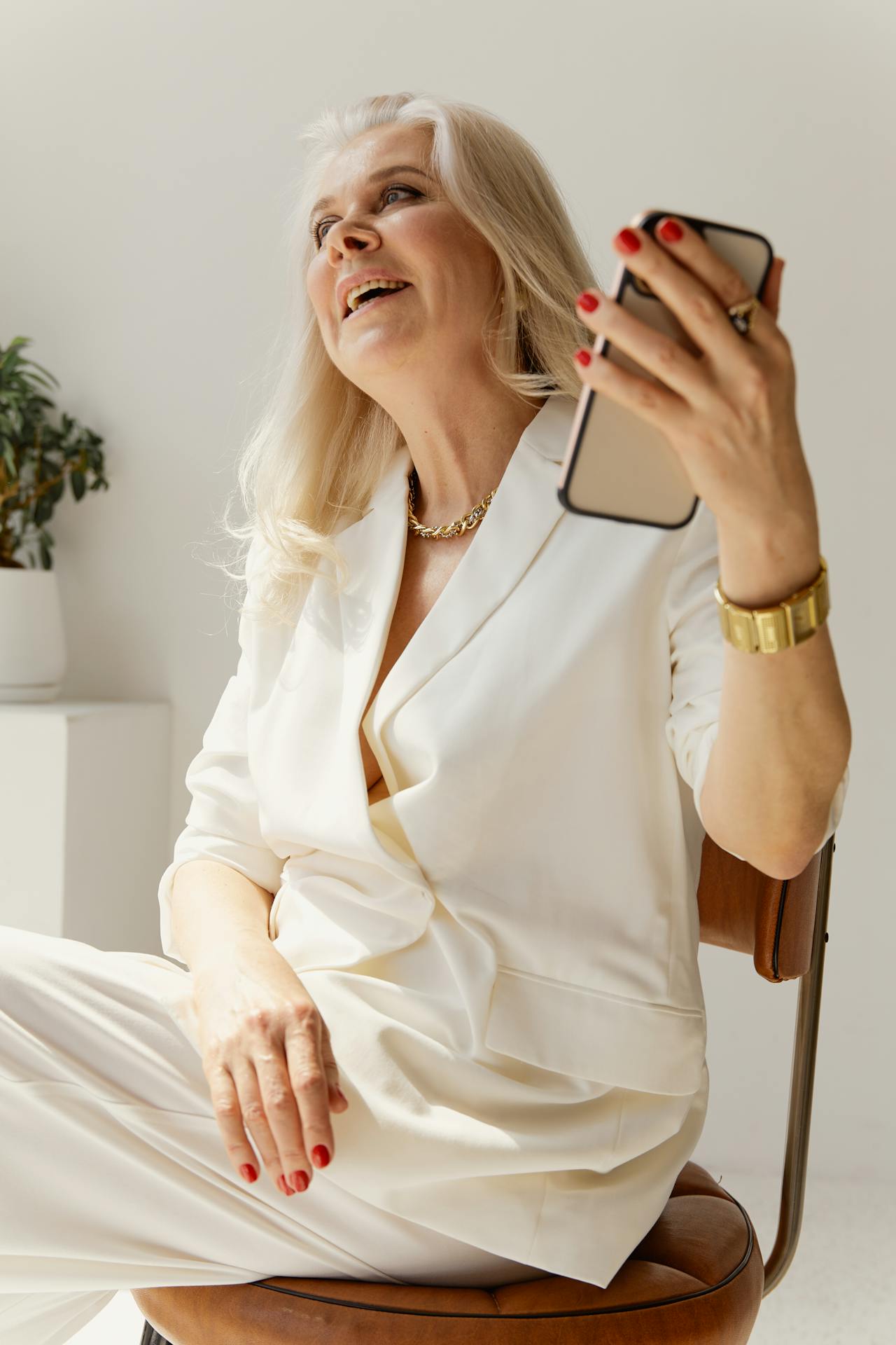 A smiling older woman holding her phone | Source: Pexels