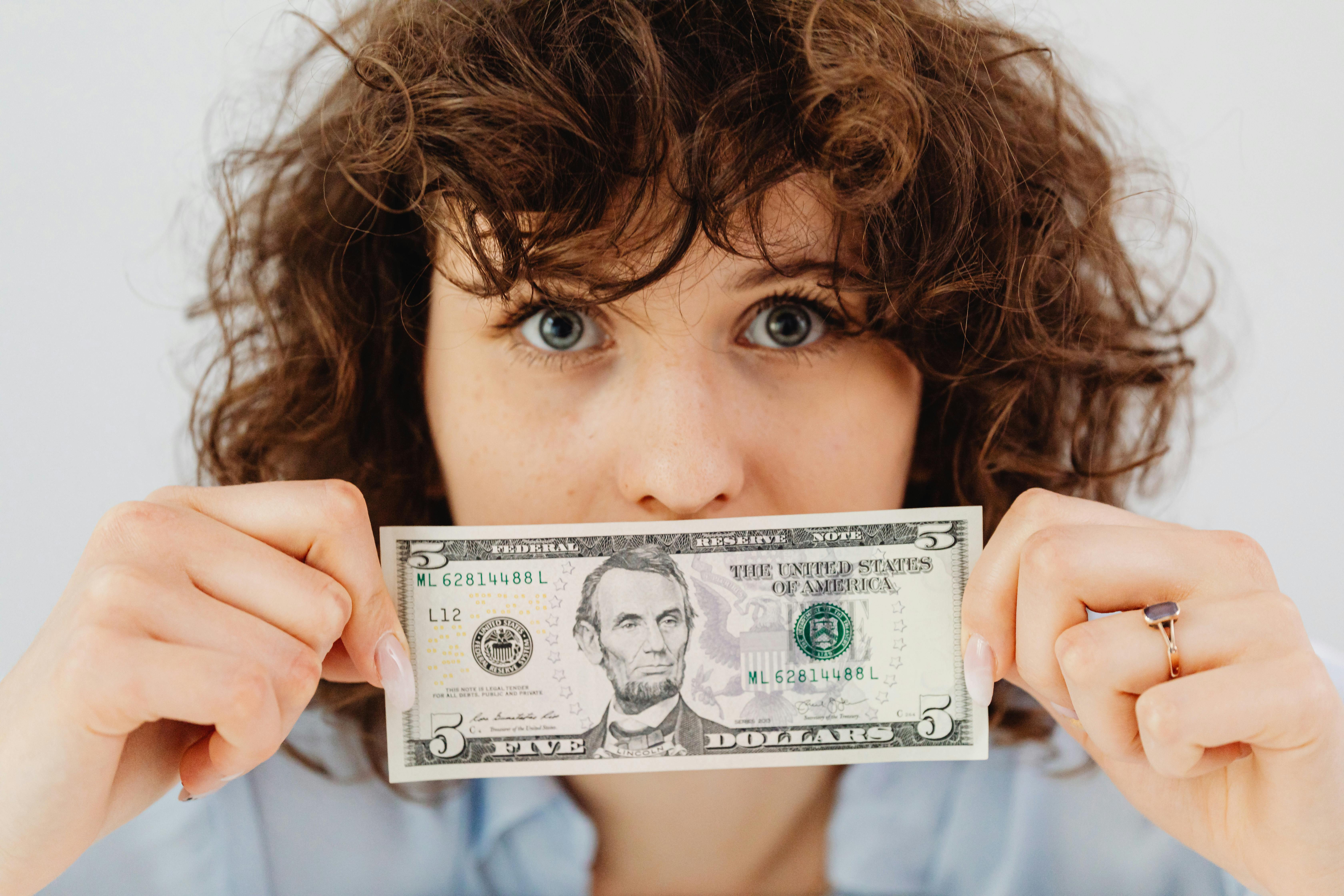 A person holding a dollar bill | Source: Pexels