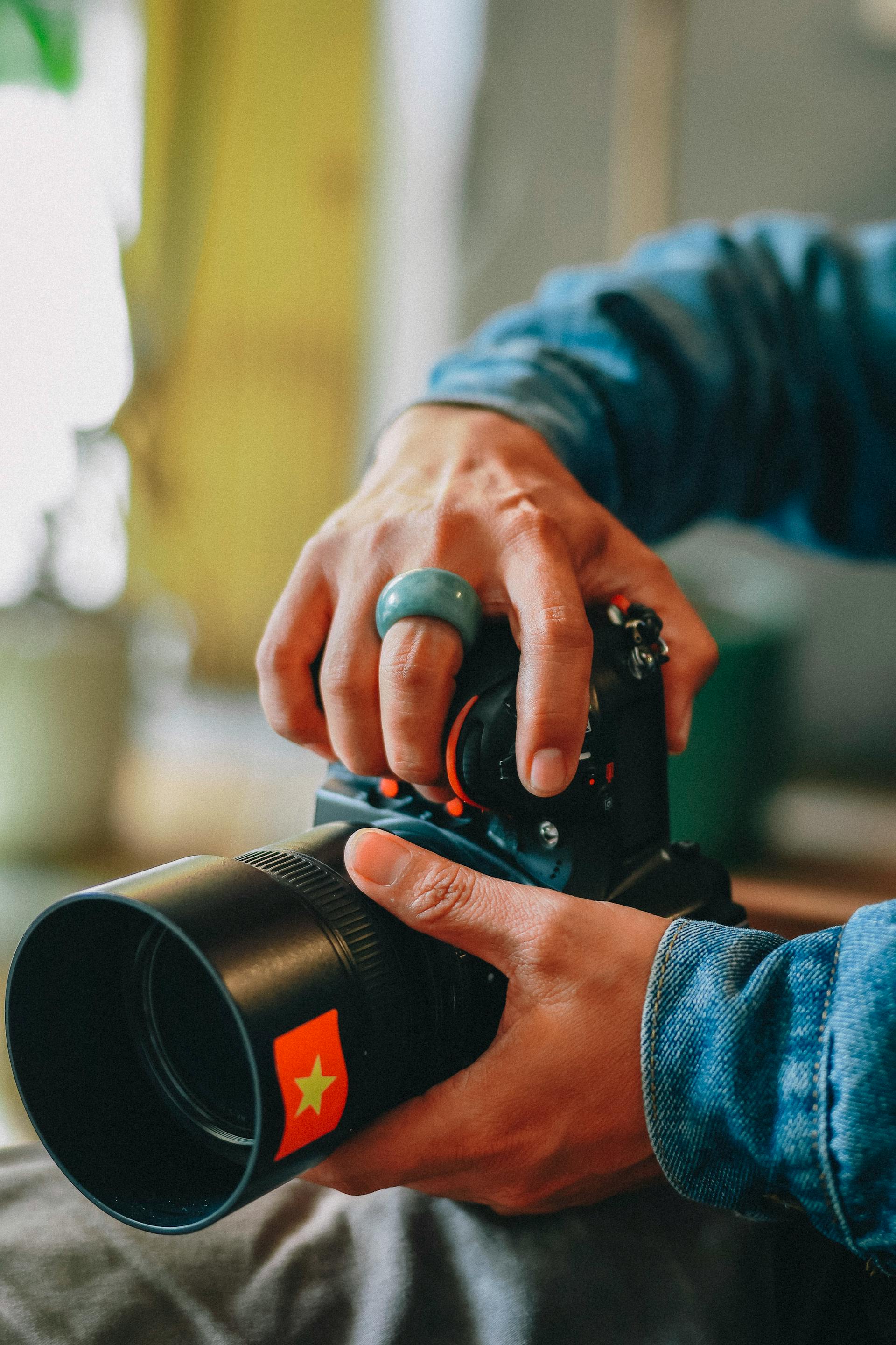 A close-up shot of a photographer adjusting their camera lens | Source: Pexels