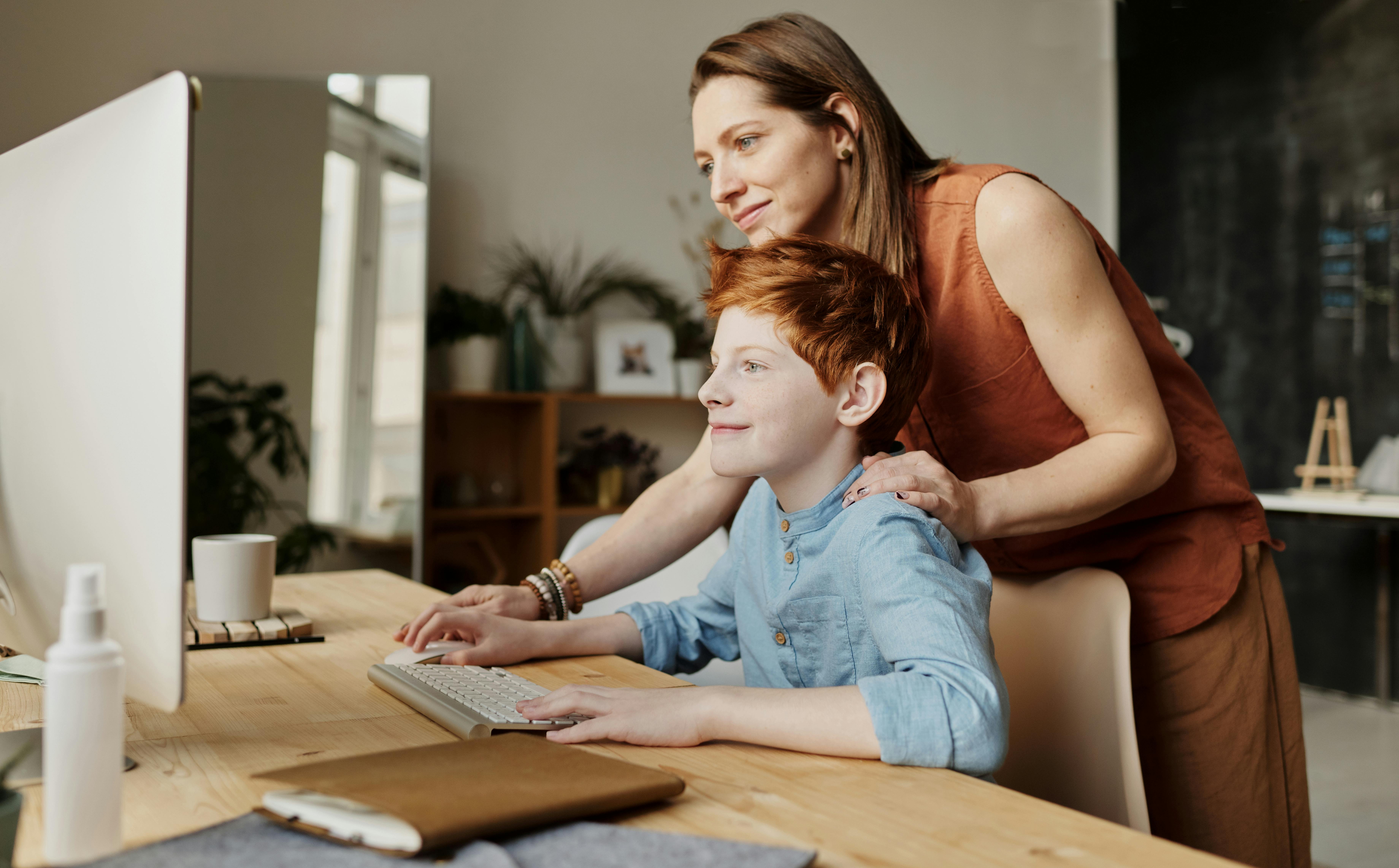 A woman with a boy working on a computer | Source: Pexels