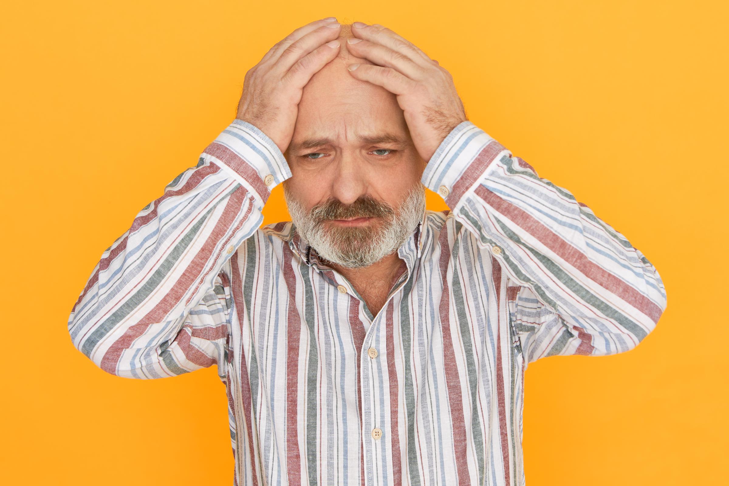 A sad man covering his head with his hands | Source: Freepik