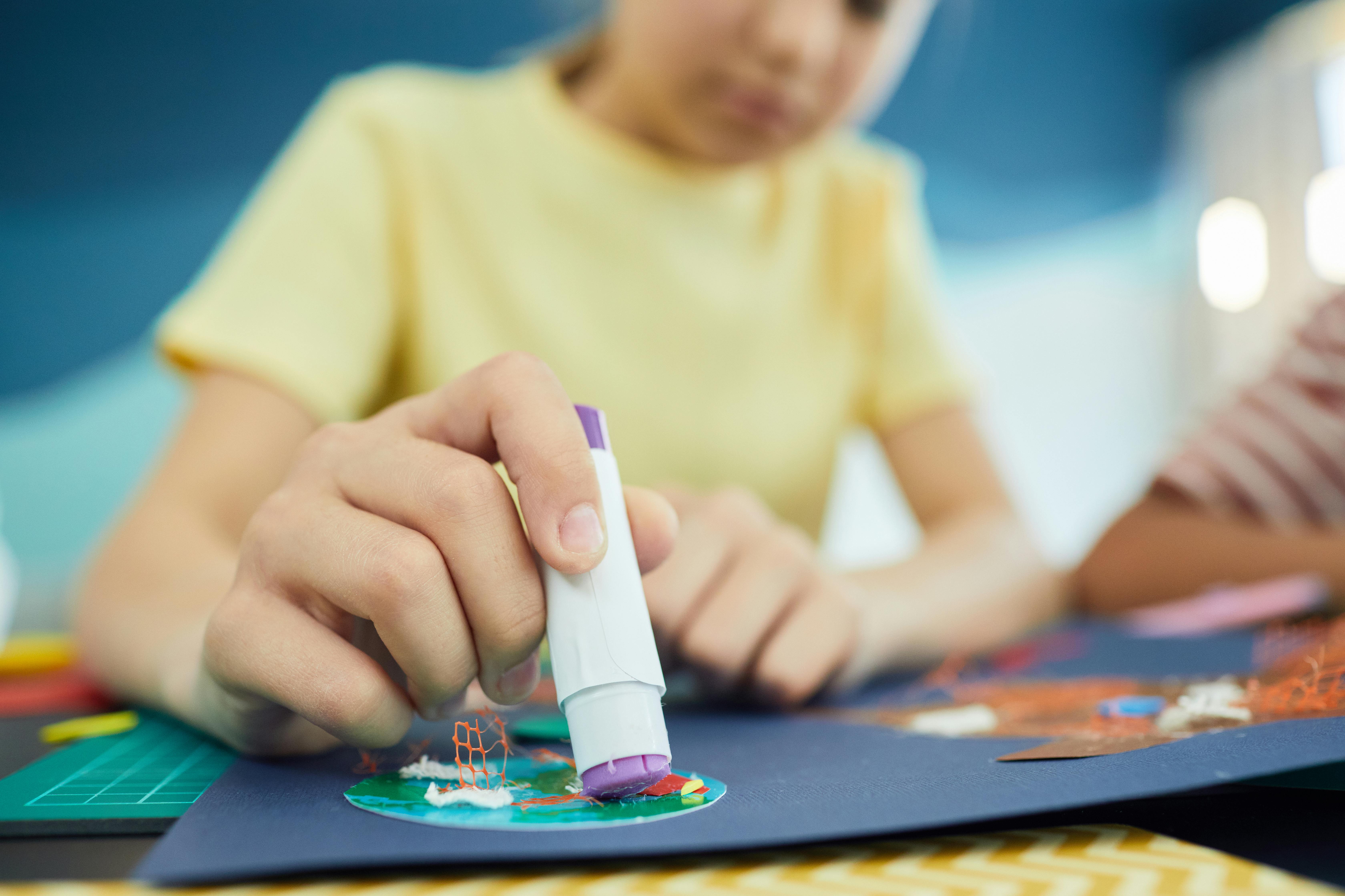 A child using a glue stick | Source: Pexels
