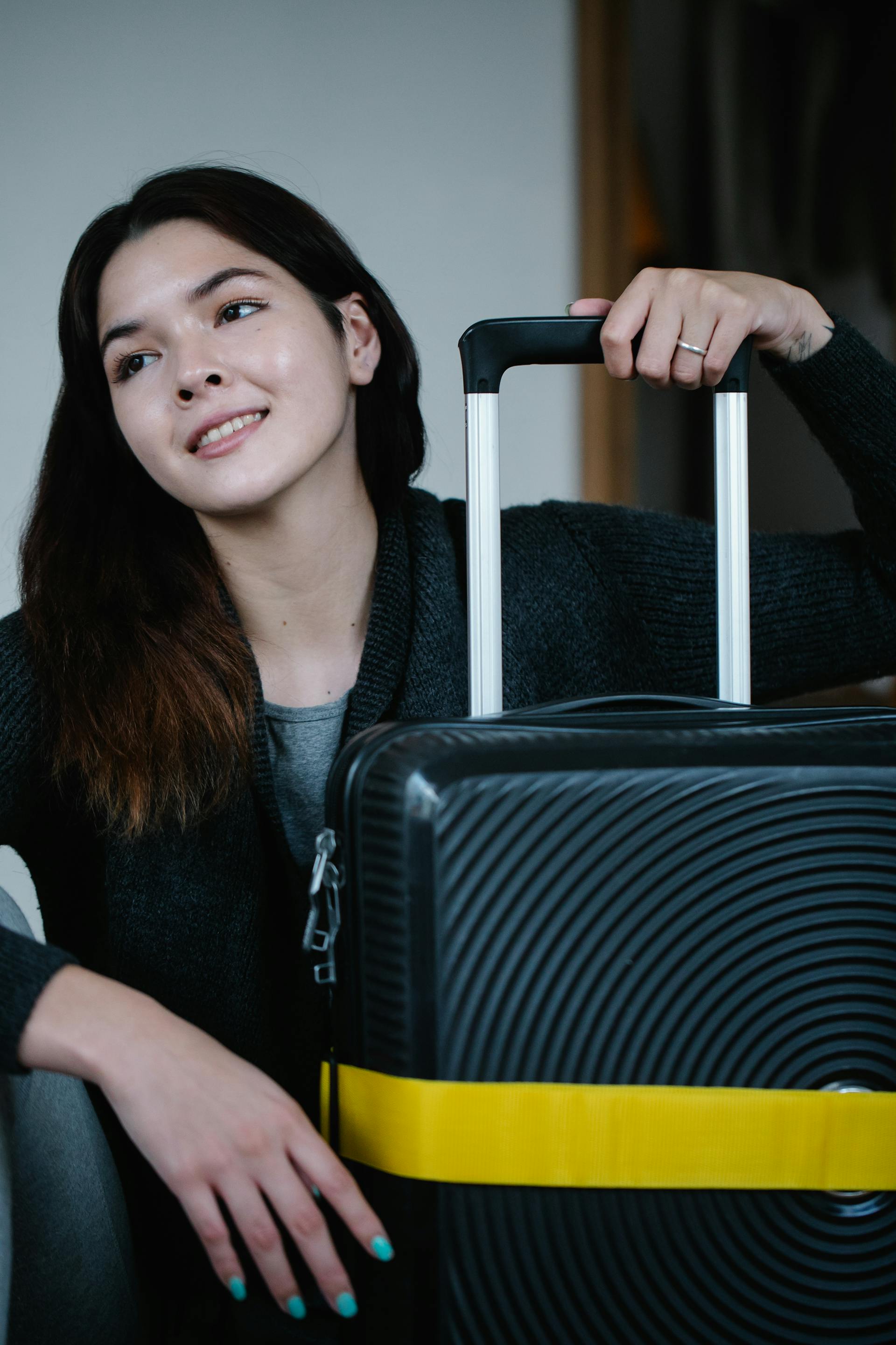 A happy woman with a piece of luggage | Source: Pexels