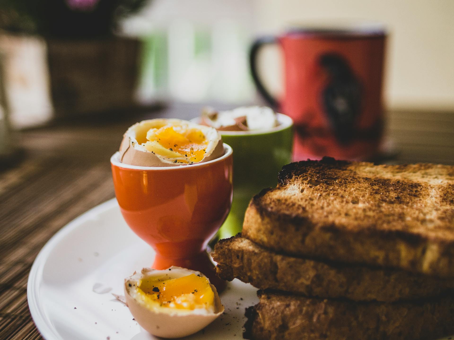A boiled egg and slices of toast | Source: Midjourney
