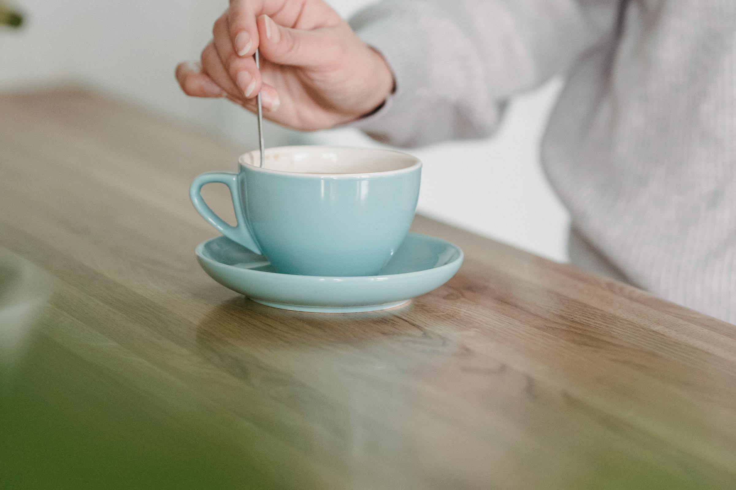 Someone stirring a cup of coffee with a spoon | Source: Pexels