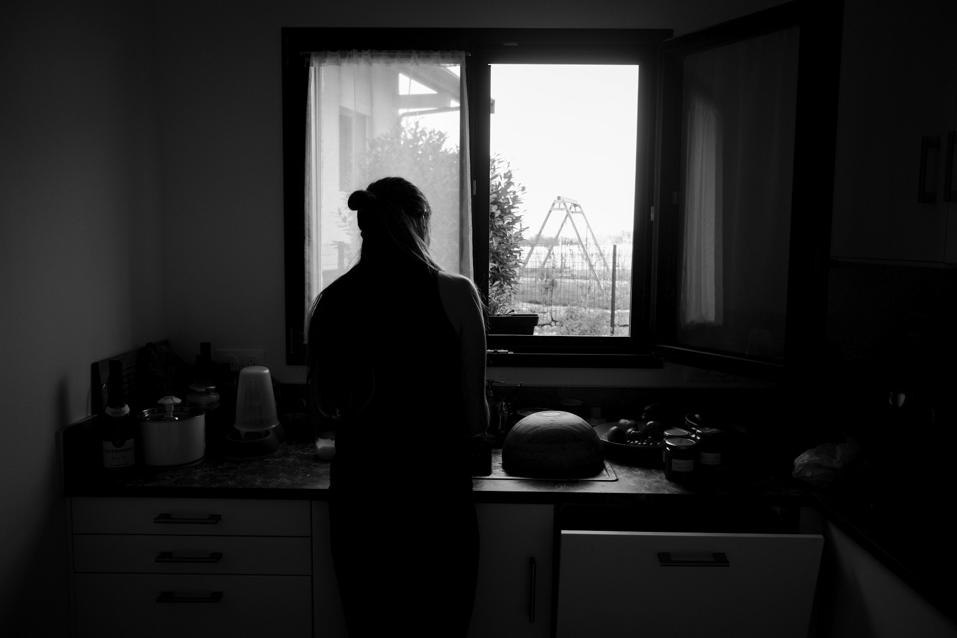 Grayscale shot of a woman standing in the kitchen | Source: Unsplash