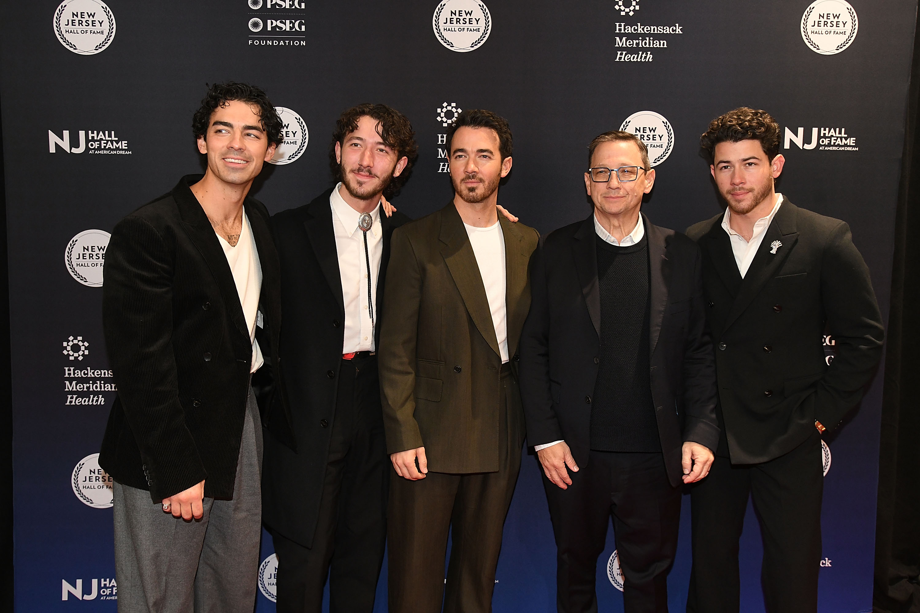 Nick, Joe, and Kevin Jonas of The Jonas Brothers with their father, Kevin Jonas Sr., and younger brother Frankie Jonas at the 2025 New Jersey Hall of Fame Induction Ceremony at American Dream on November 21 in East Rutherford, New Jersey. | Source: Getty Images