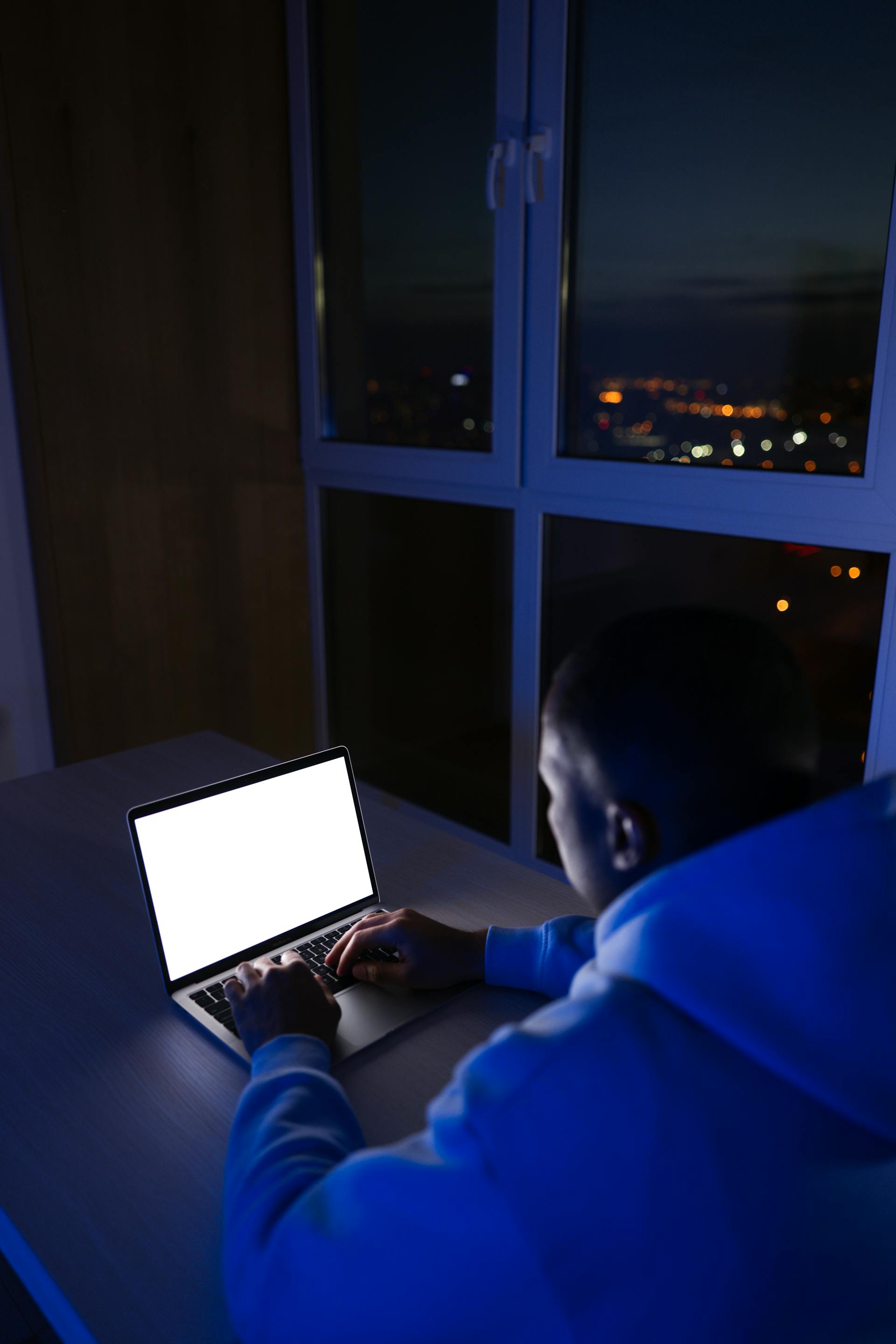 A man working on a laptop at night | Source: Pexels