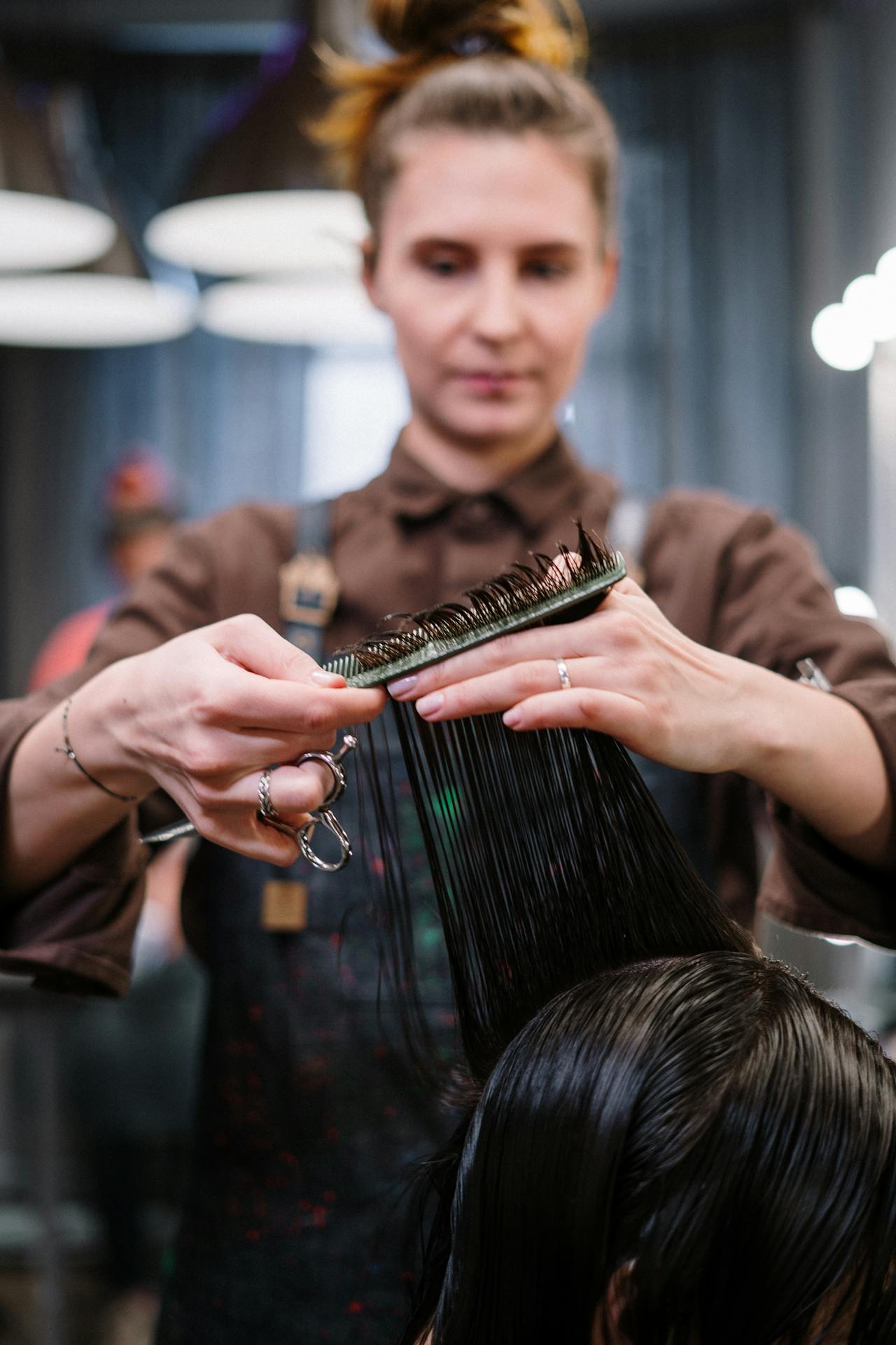 A hair stylist cutting a woman's hair | Source: Pexels