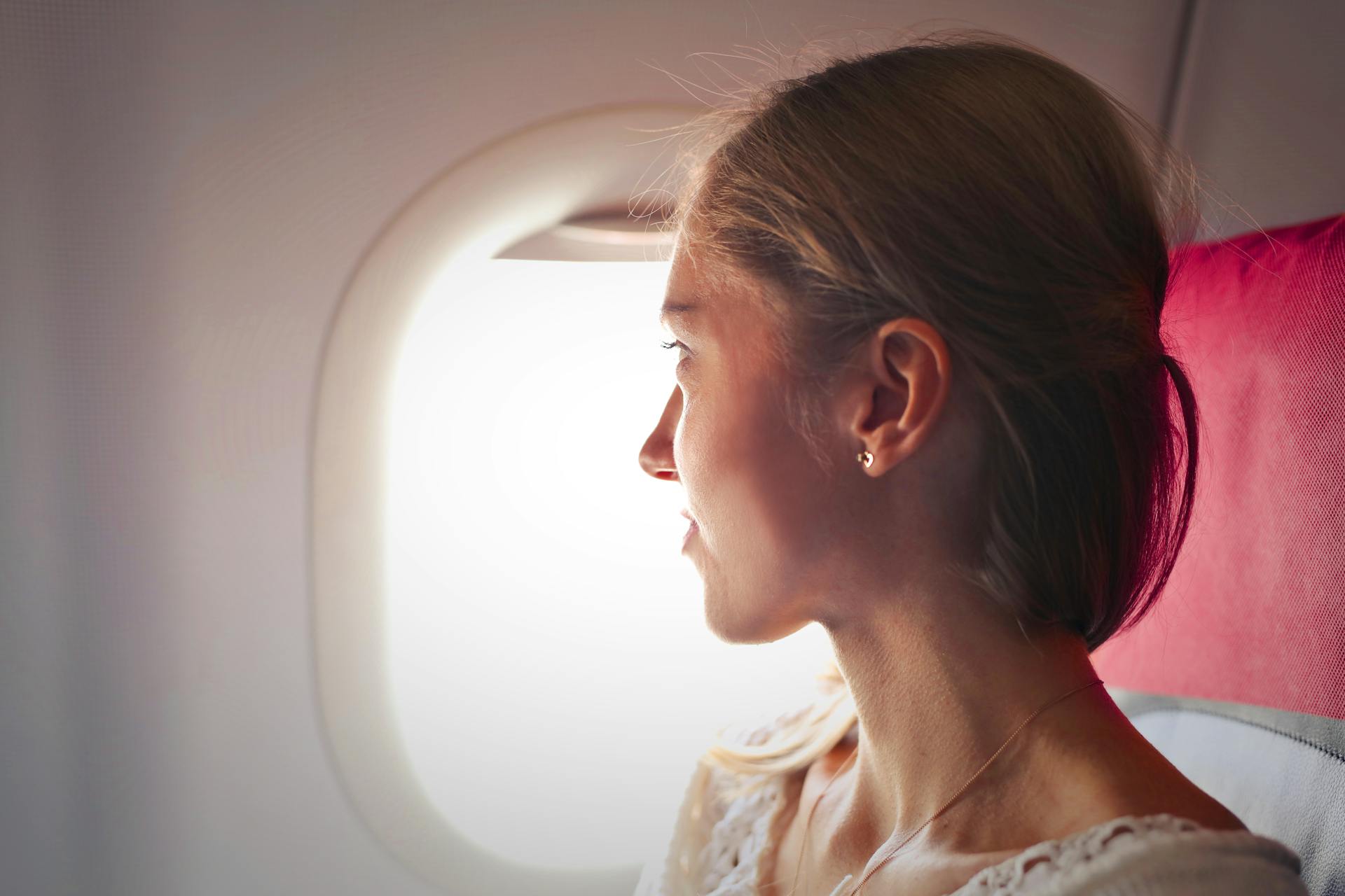 Uma mulher olhando pela janela de um avião | Fonte: Pexels