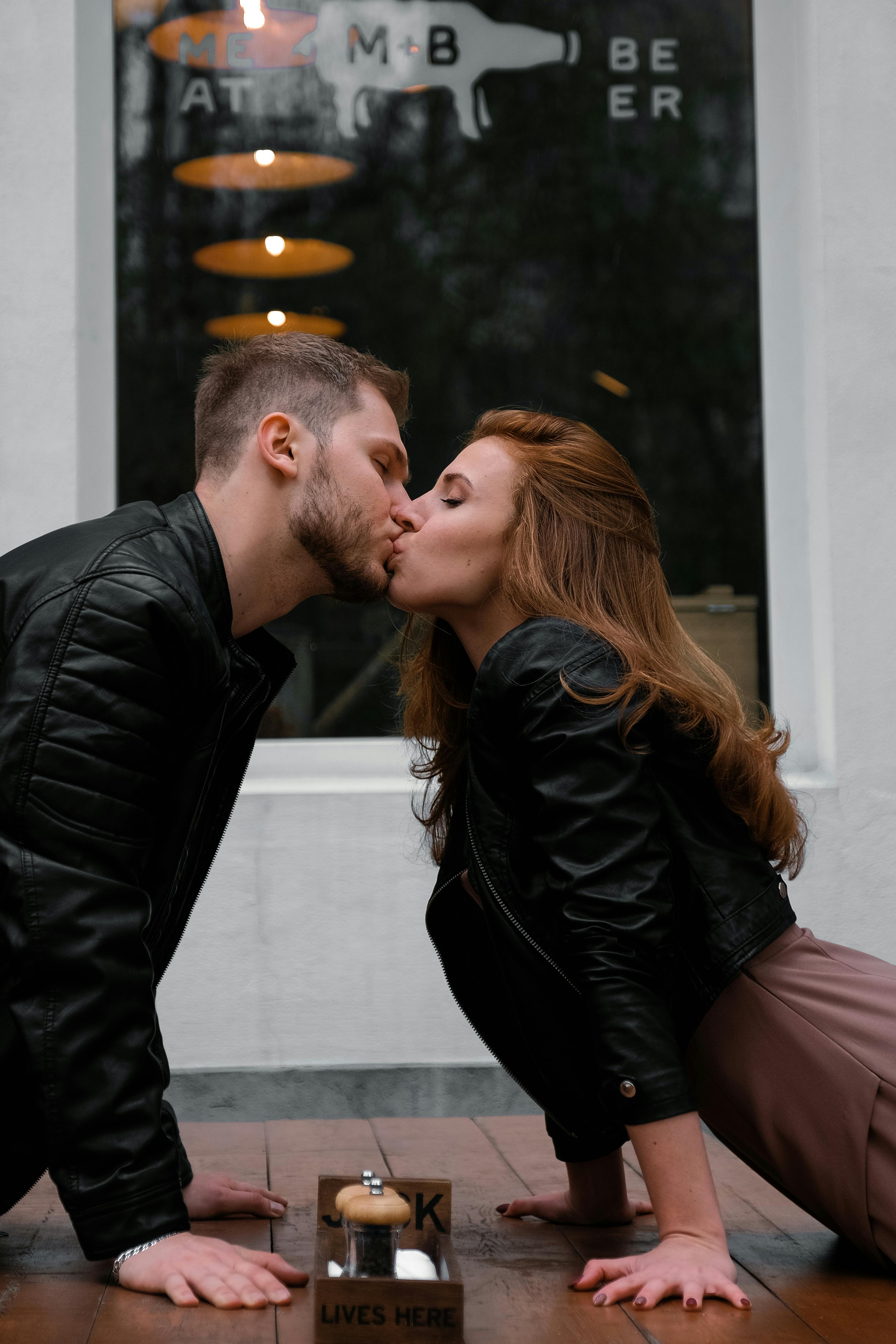 Man and woman kissing over a table | Source: Pexels