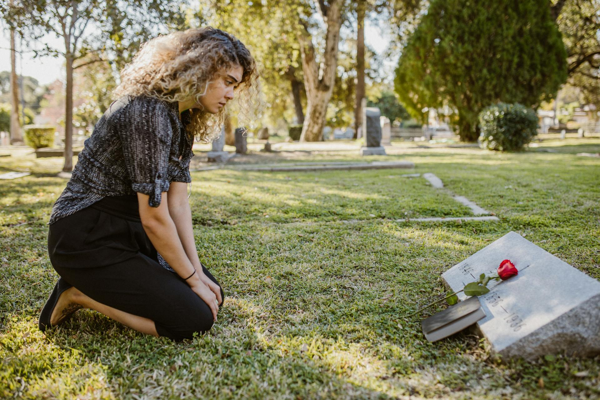 A woman sitting near a grave | Source: Pexels