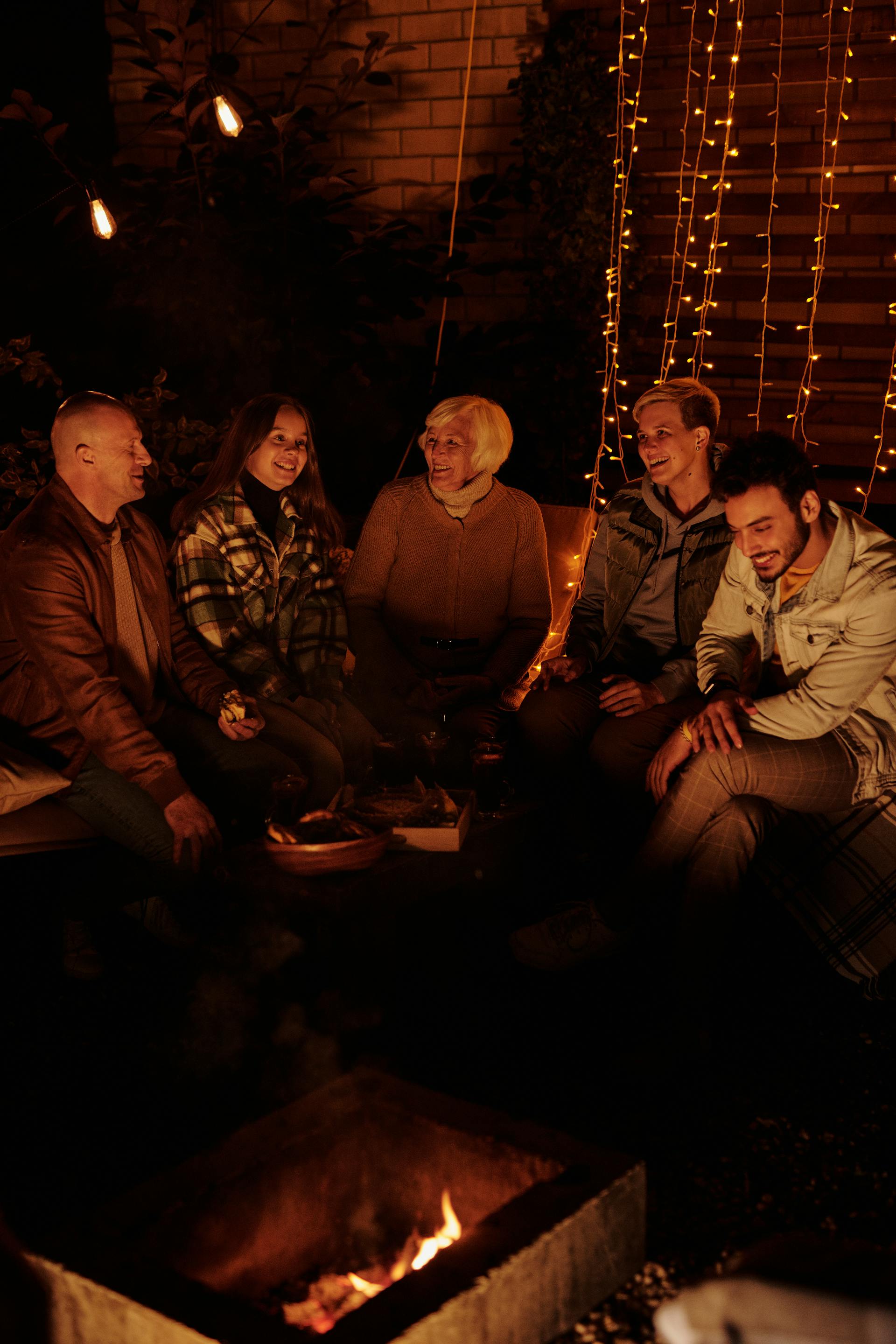 A family gathering around bonfire at night | Source: Pexels