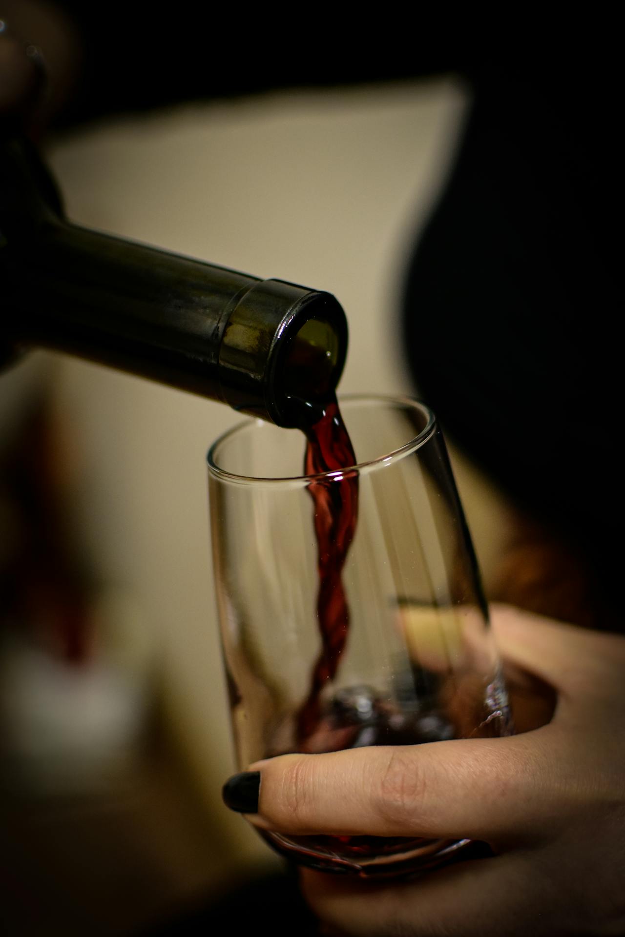 Woman pouring wine into a glass | Source: Pexels