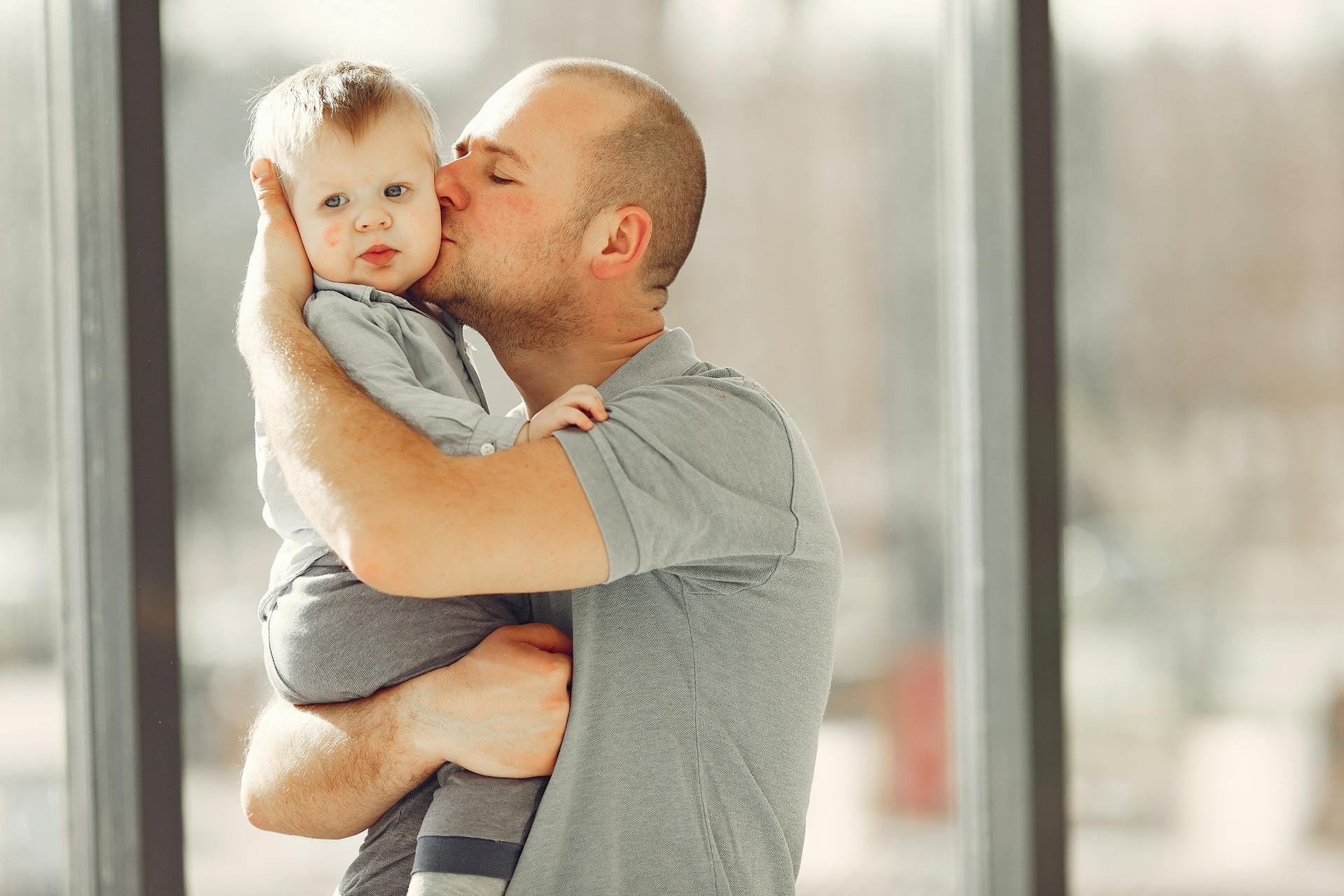 A man carrying and kissing his child | Source: Pexels